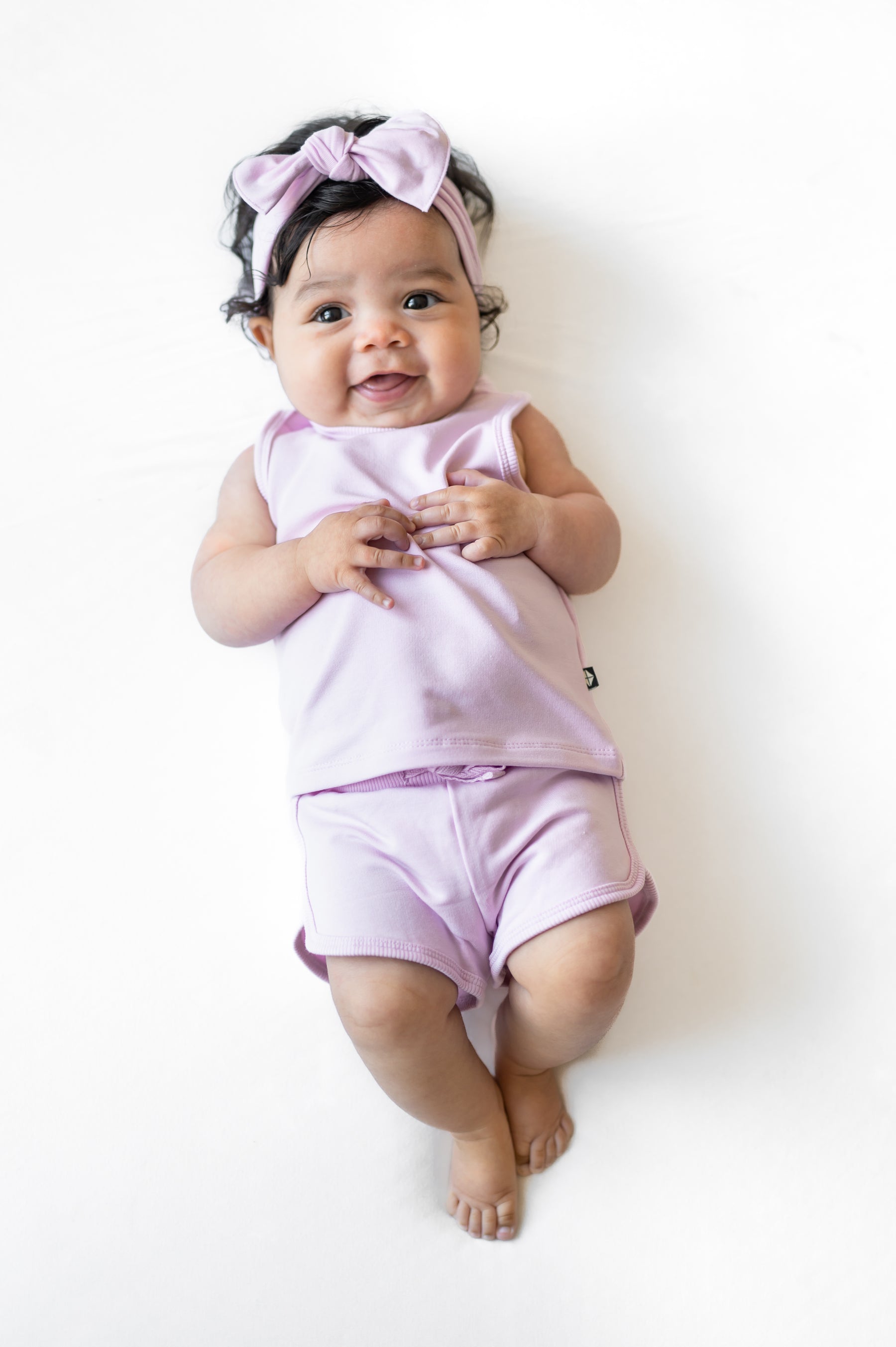 Infant wearing the Tank Jogger Set in Thistle laying on a white surface