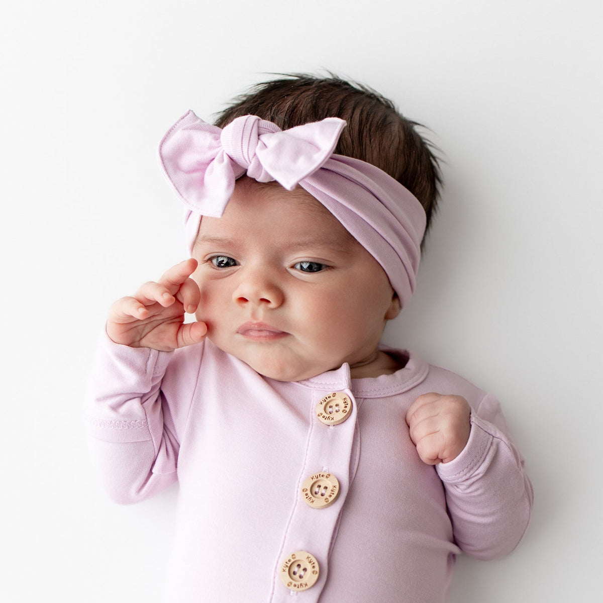 Knotted Bow Headband in Thistle shown on a newborn baby