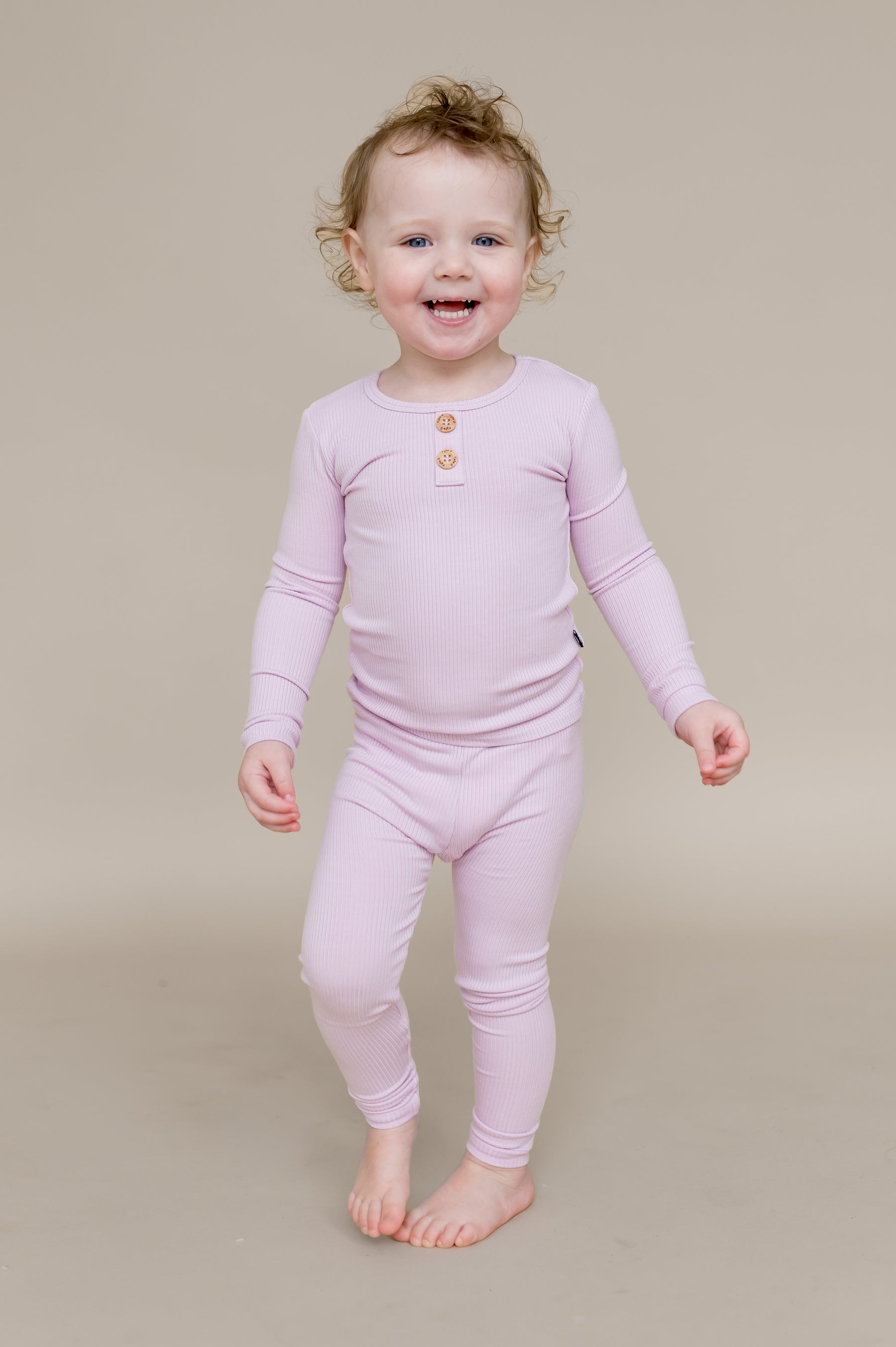 Smiling girl wearing the Ribbed Henley Set in Thistle