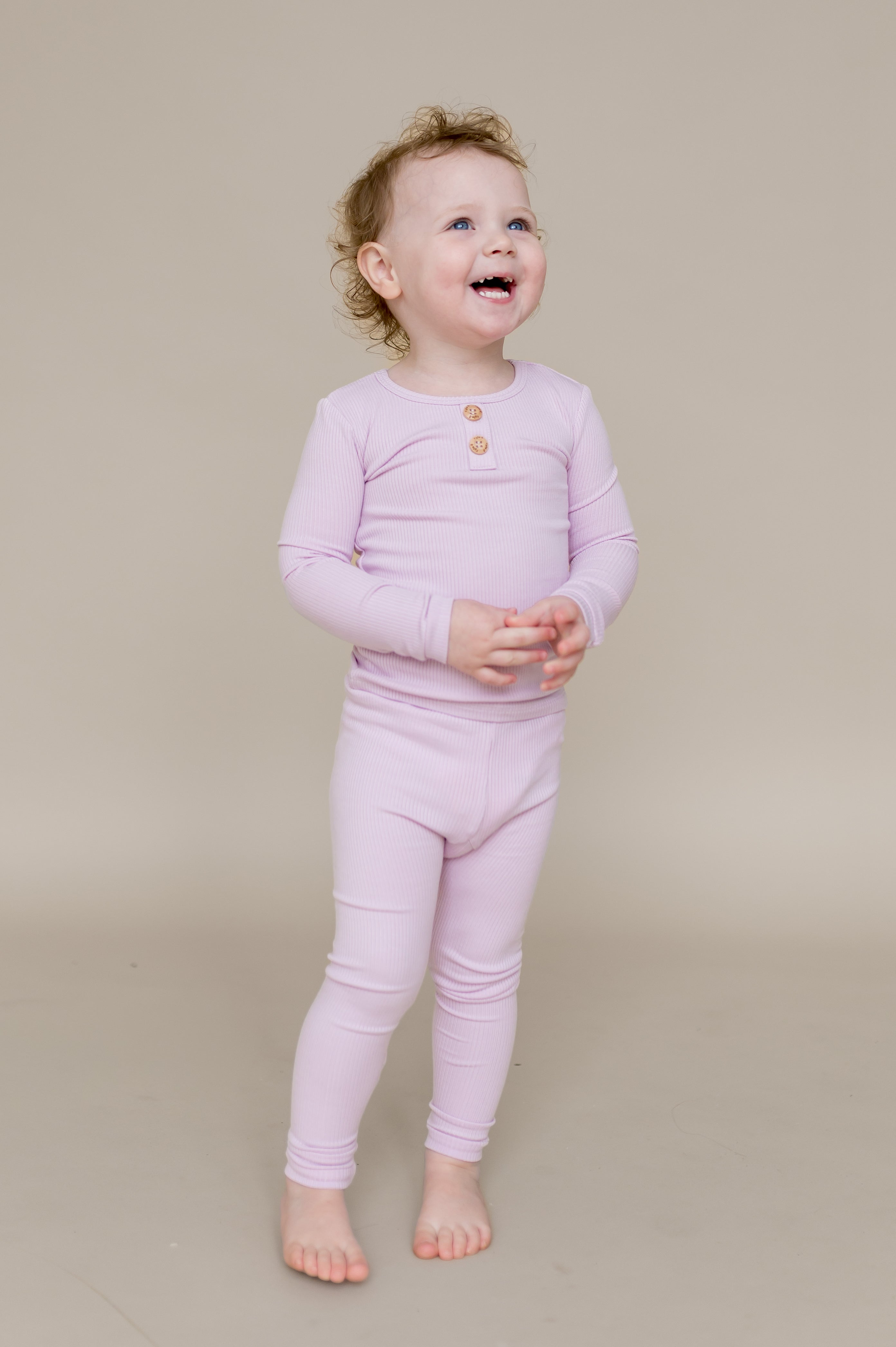 Young smiling girl looking up wearing the Ribbed Henley Set in Thistle