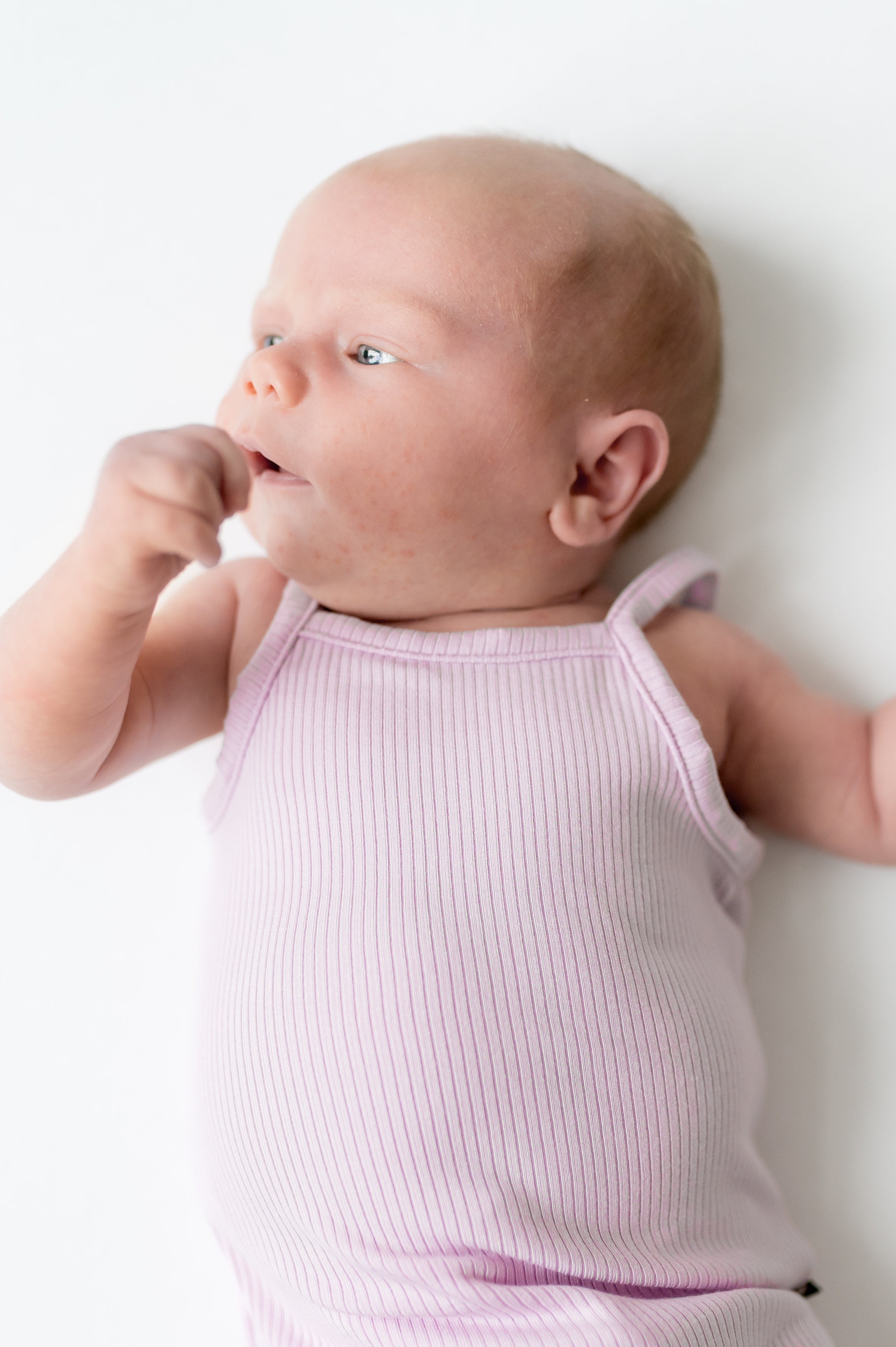 Close up of newborn wearing the Ribbed Spaghetti Strap Bodysuit in Thistle