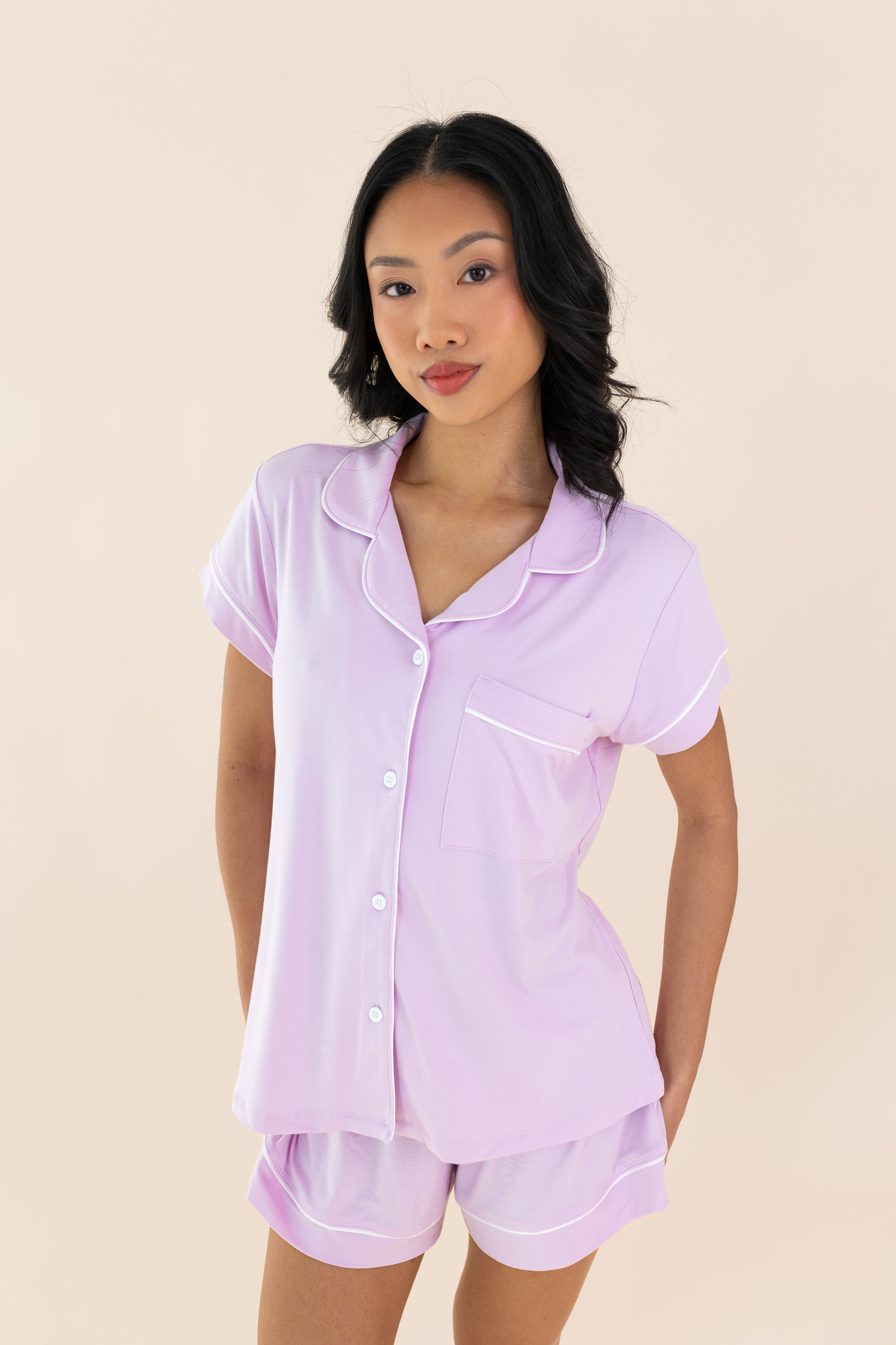 Woman wearing a light purple pajama set against a beige background