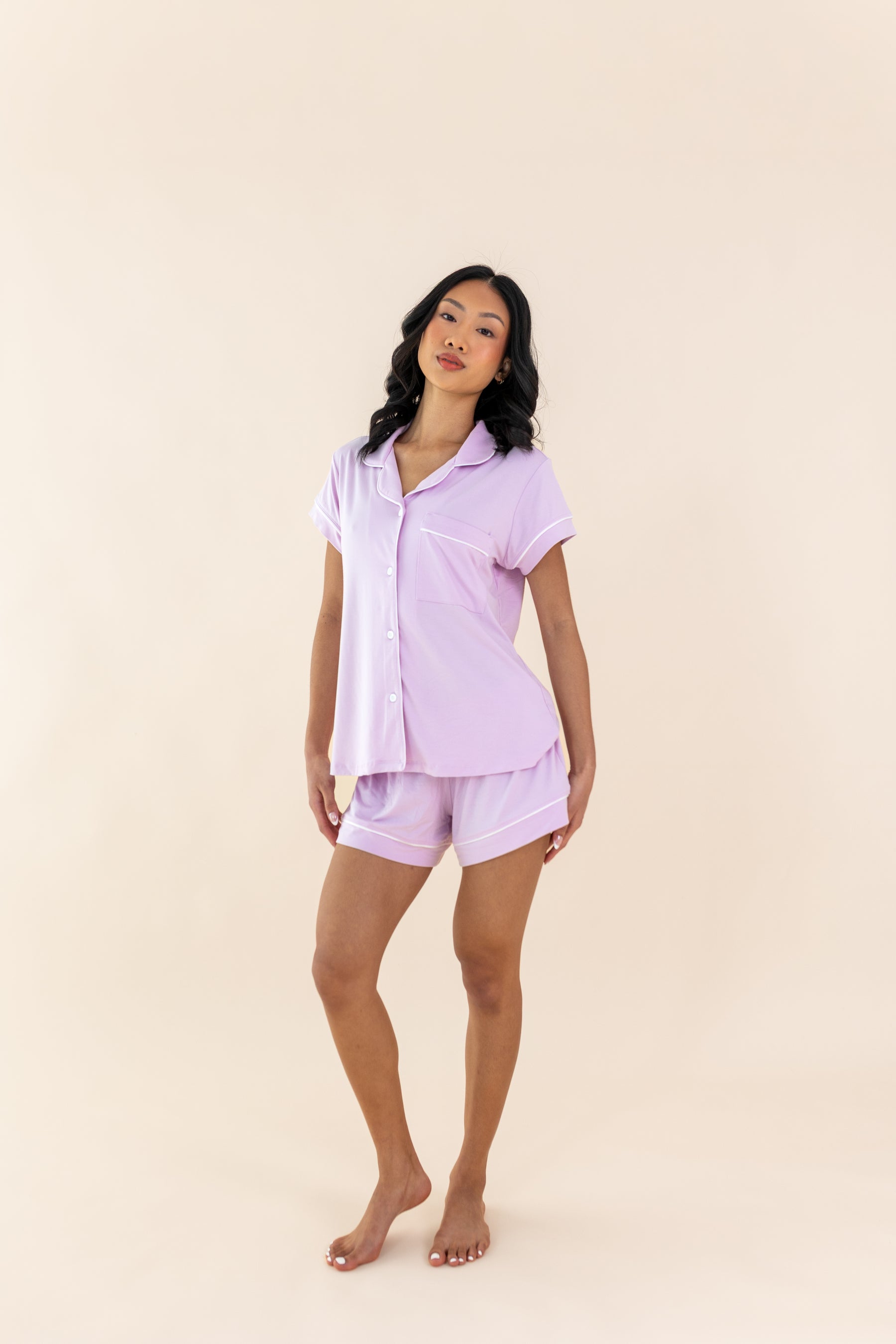 Woman wearing a light purple pajama set on a beige background