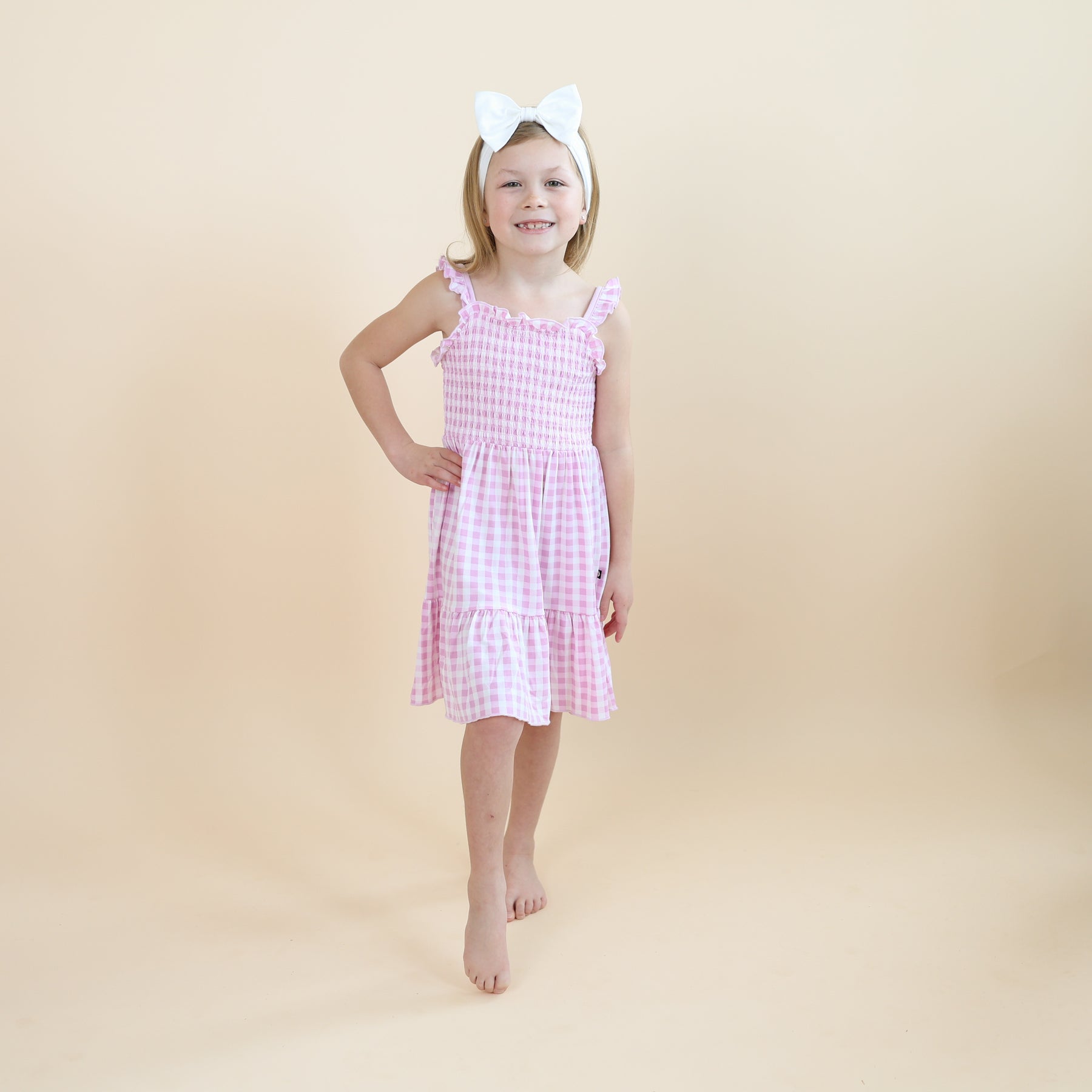 Young girl posing modeling the Smocked Dress in Gingham Thistle