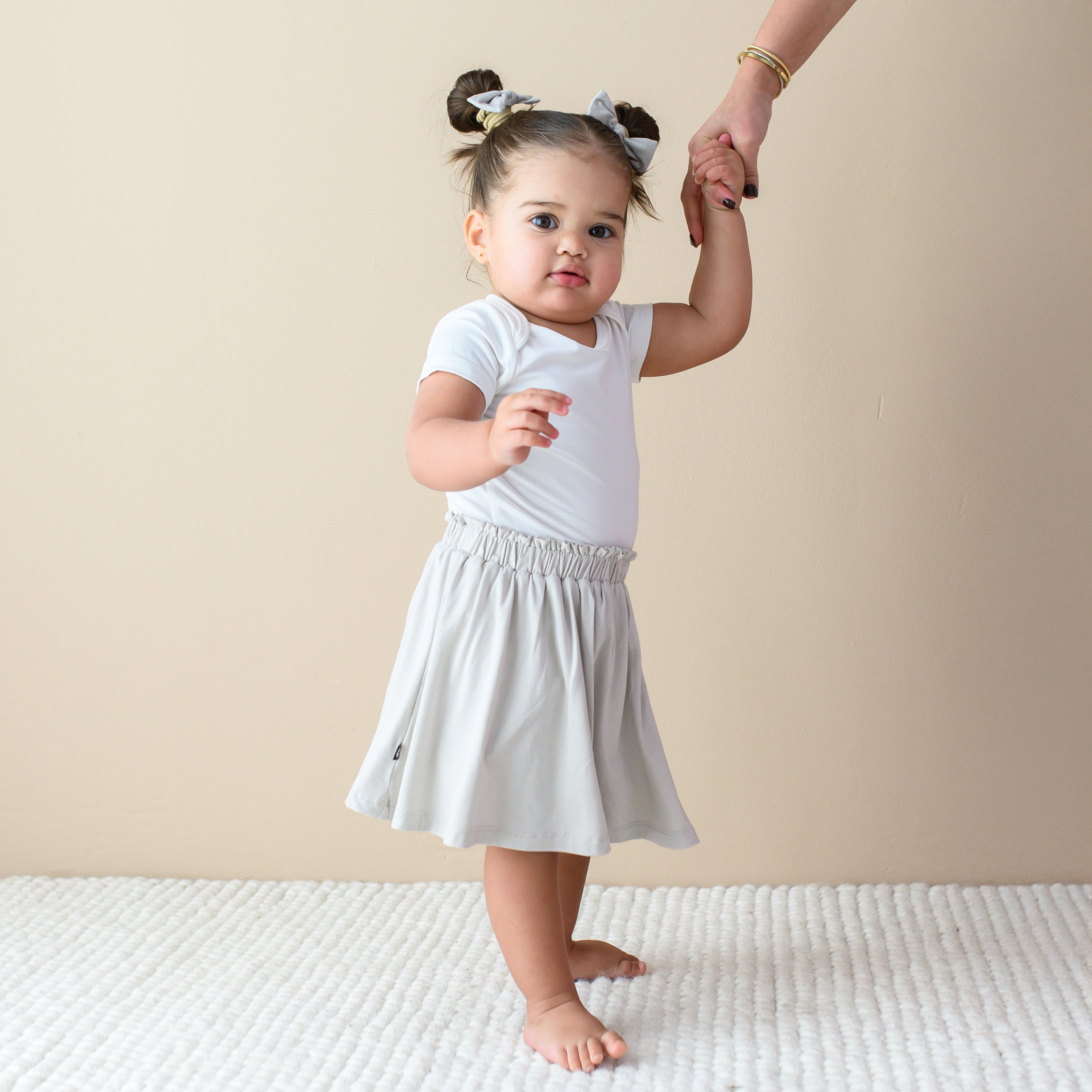 toddler modeling Toddler Skort in Oat and bodysuit in cloud