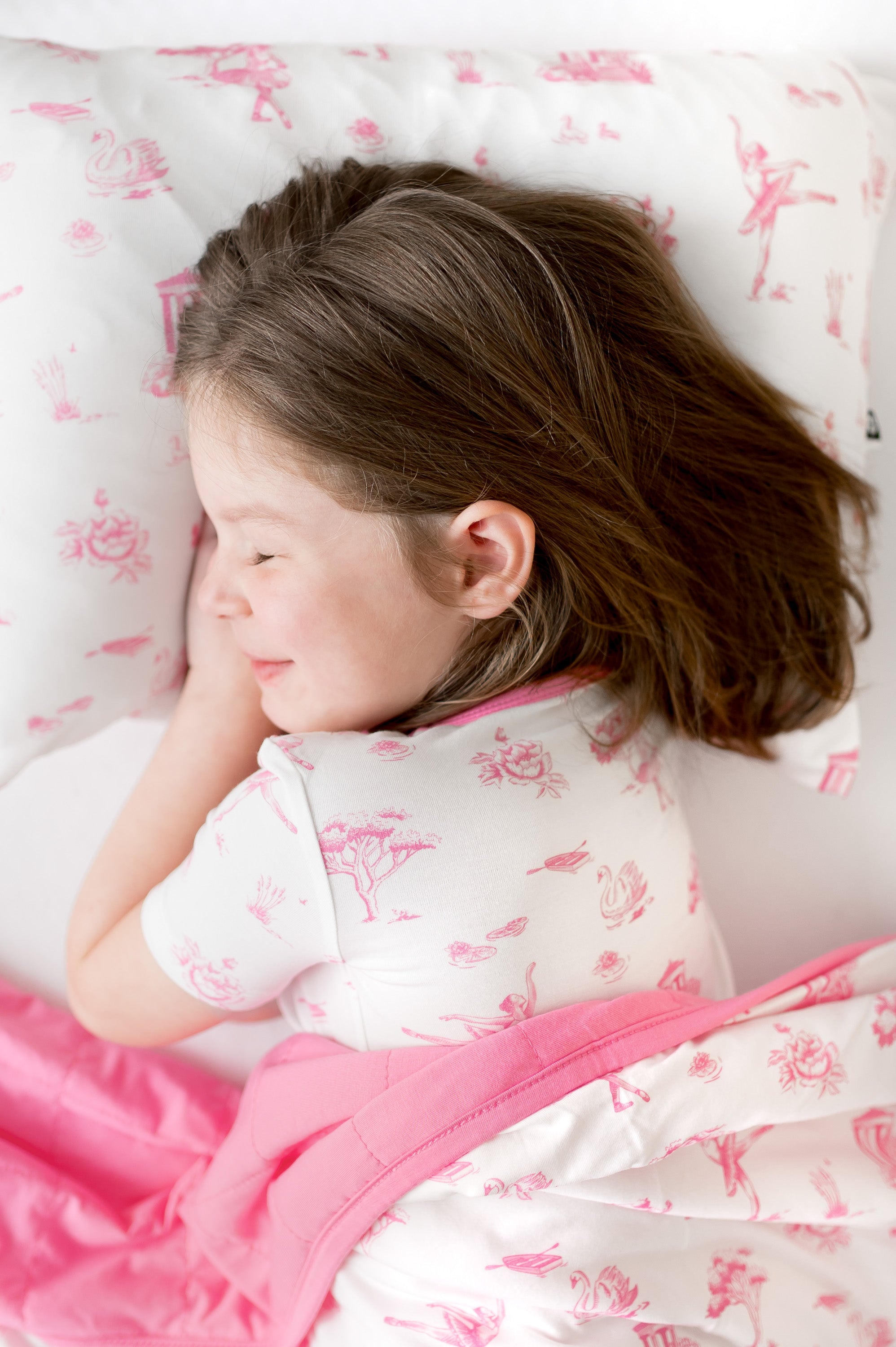 Young girl laying on a Standard Pillowcase in Toile Ballet