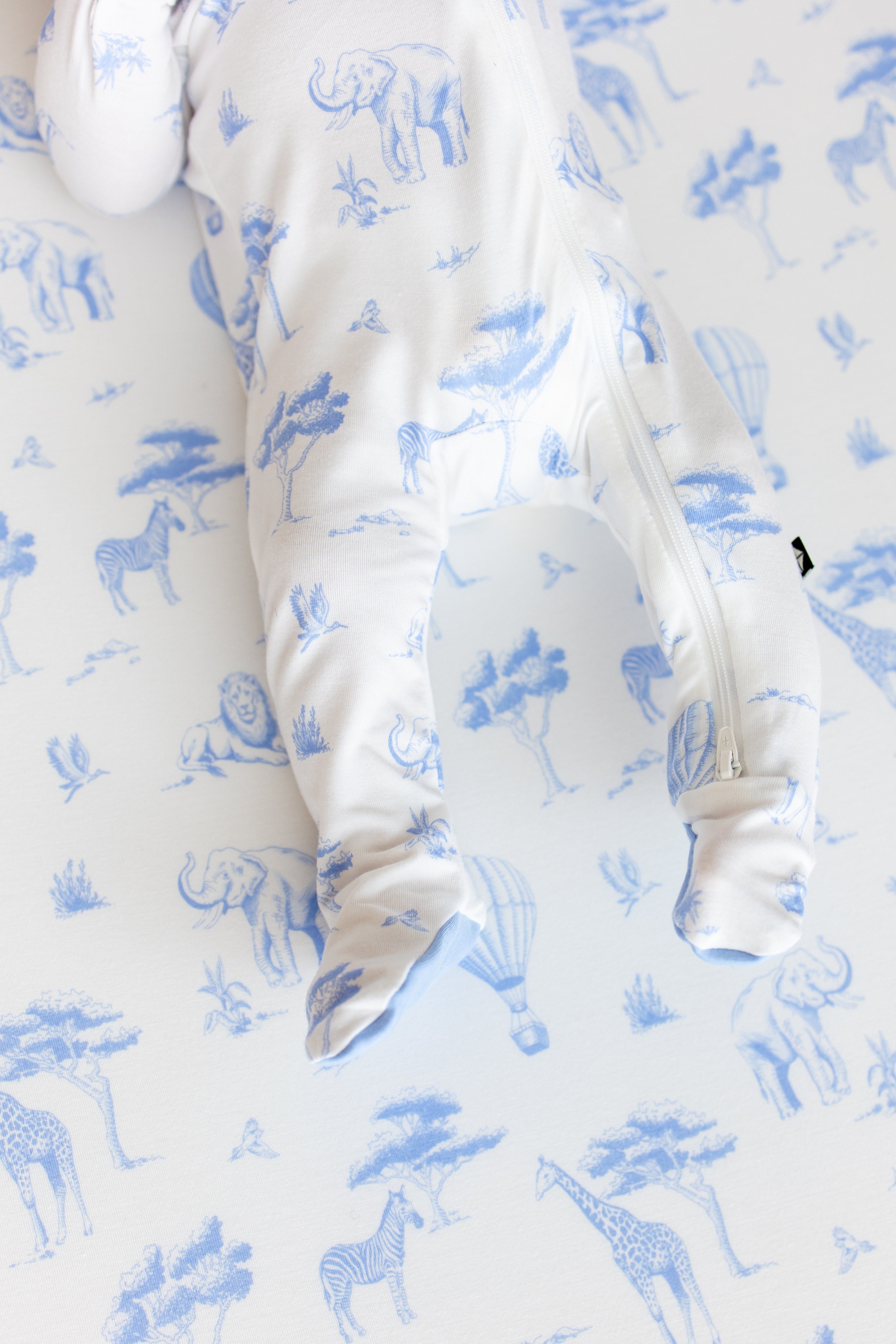 Close up of the zipper closure and enclosed feet on the Zippered Footie in Toile Safari