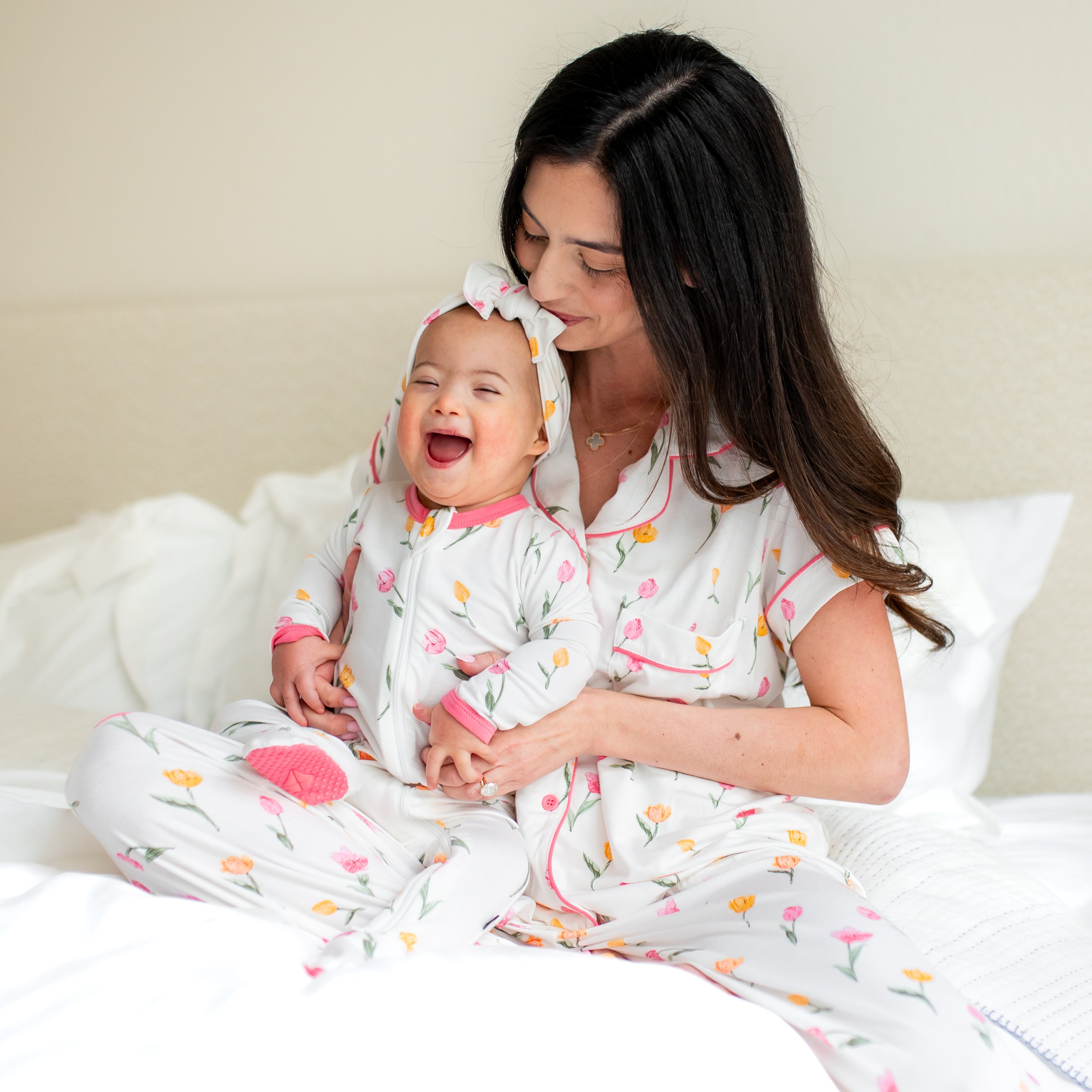 Mother and daughter sitting on a bed matching in tulip