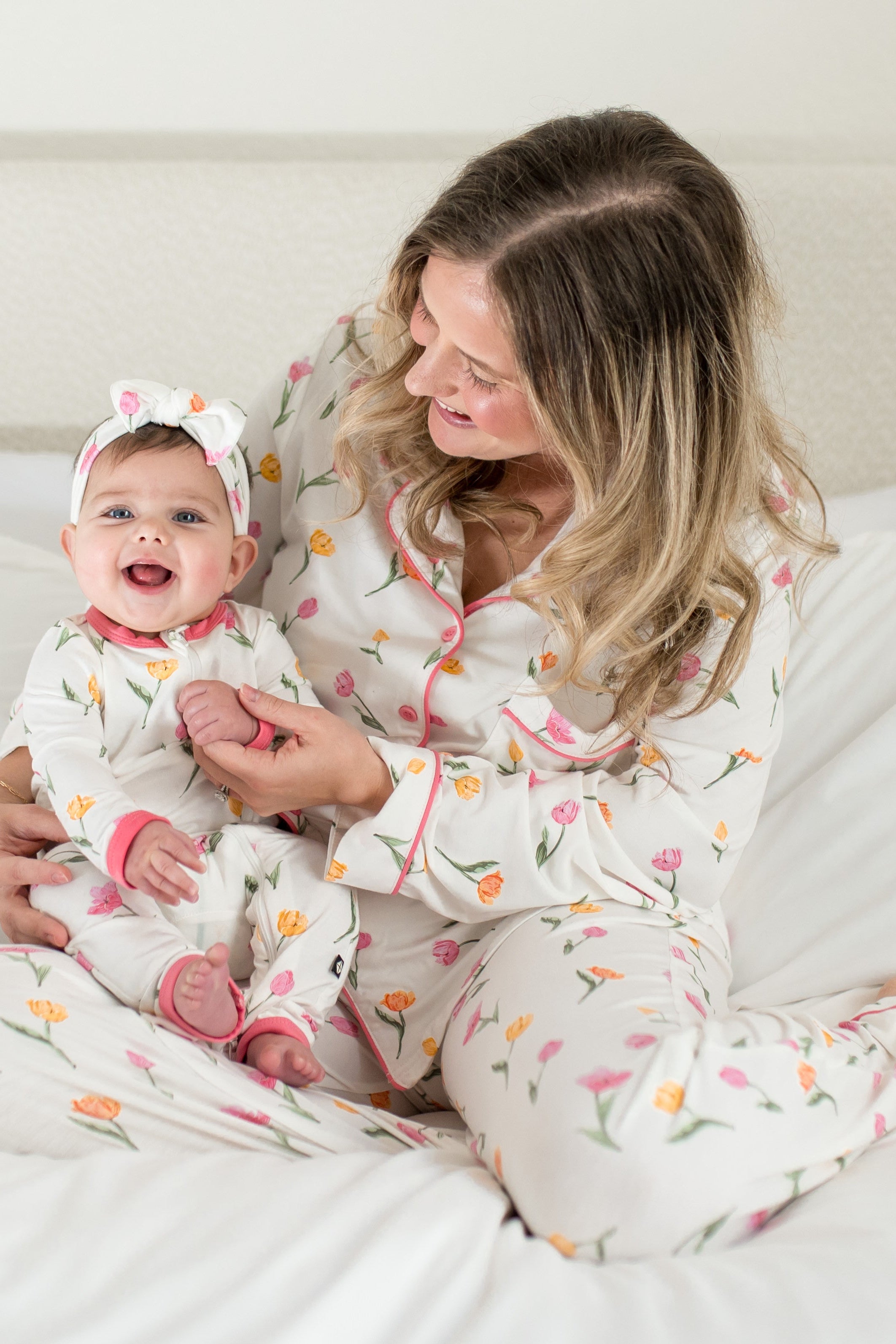 Mother and daughter sitting on a bed matching in the floral print tulip