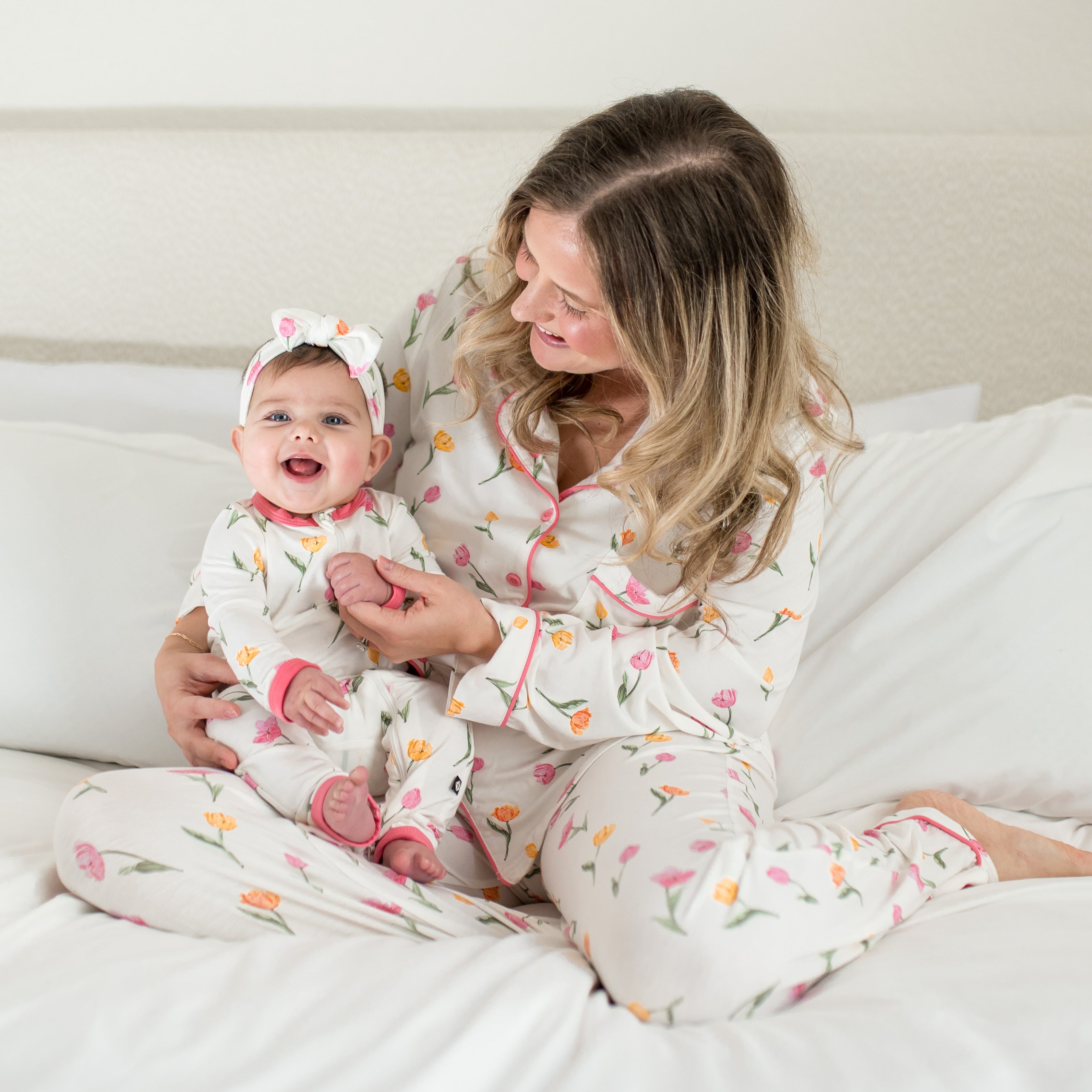 Mother and daughter sitting on a bed wearing the tulip print