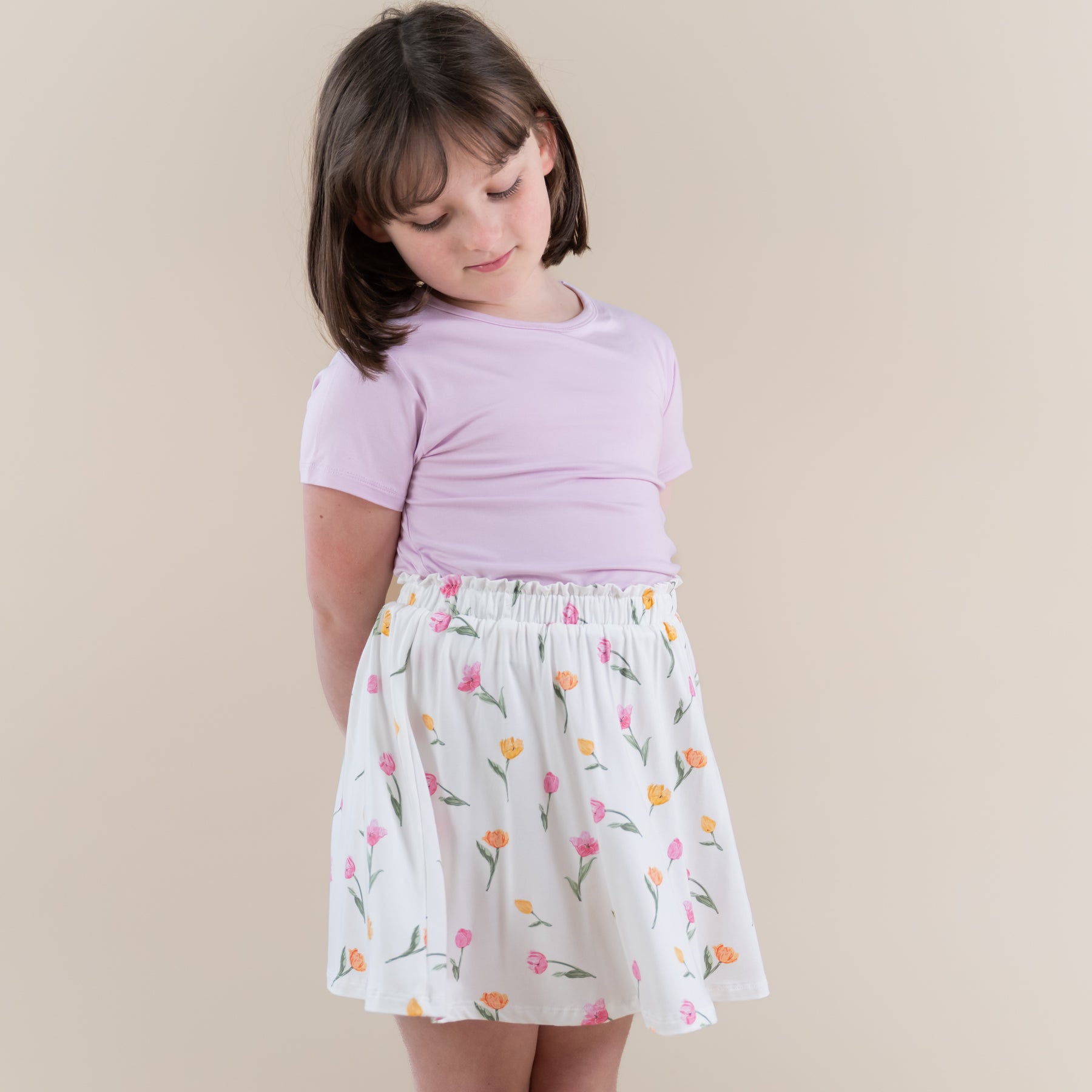 Young girl posing wearing the Toddler Skort in Tulip and Thistle basic tee