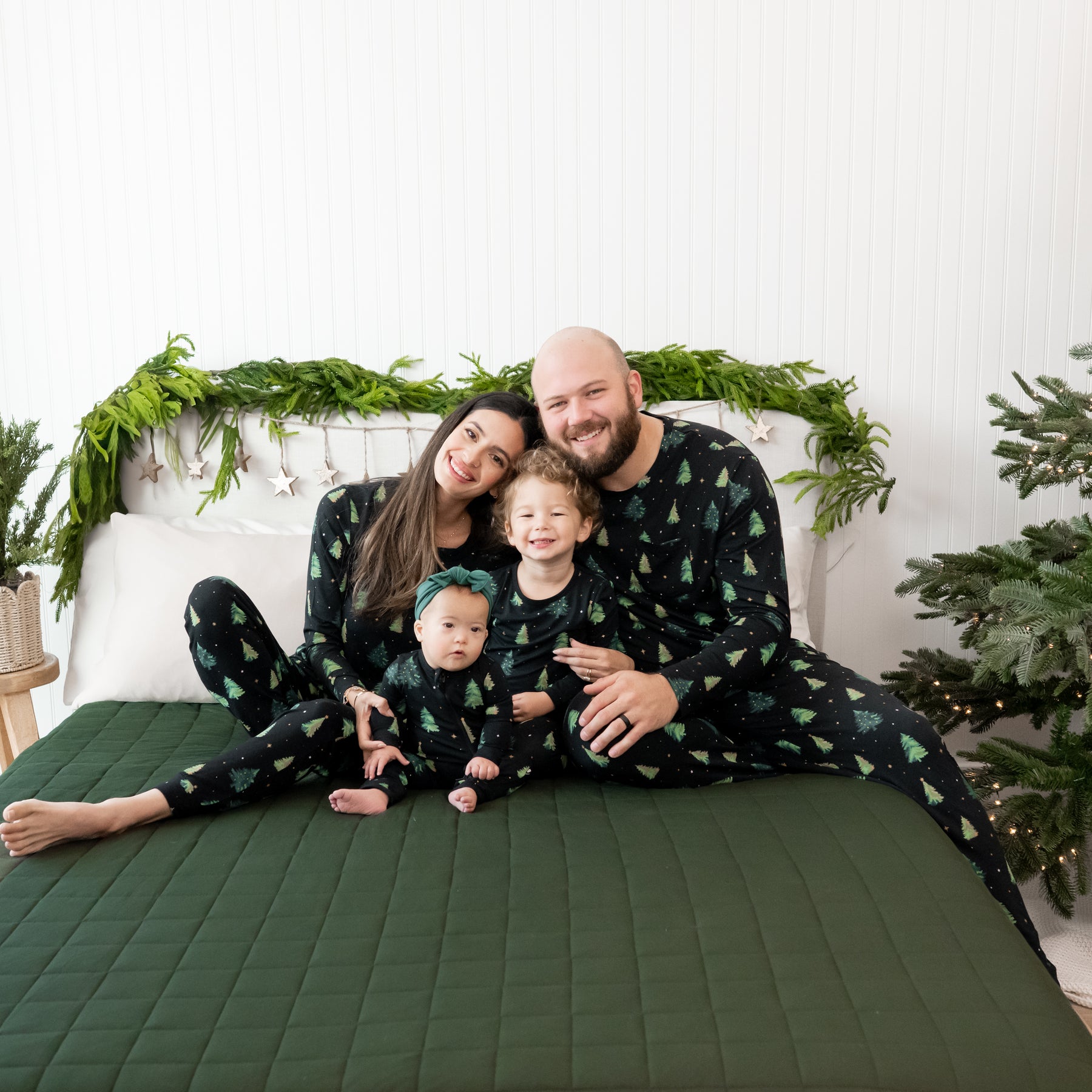Family of four sitting on the couch matching in various Twinkle Tree items
