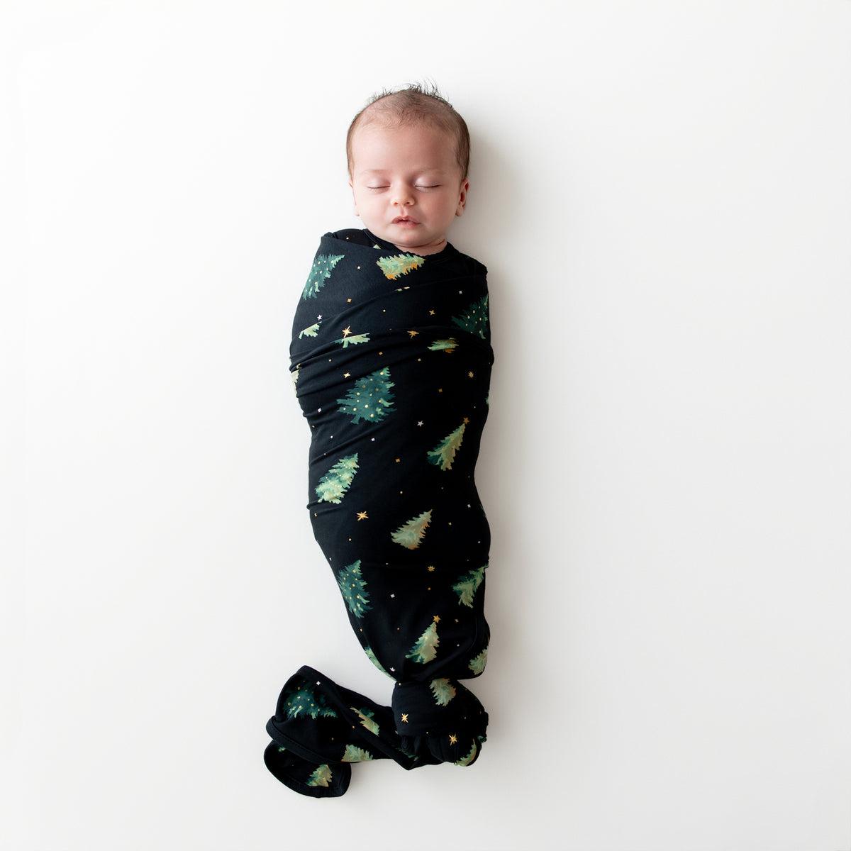 Sleeping infant swaddled in the Swaddle Blanket in Twinkle Tree