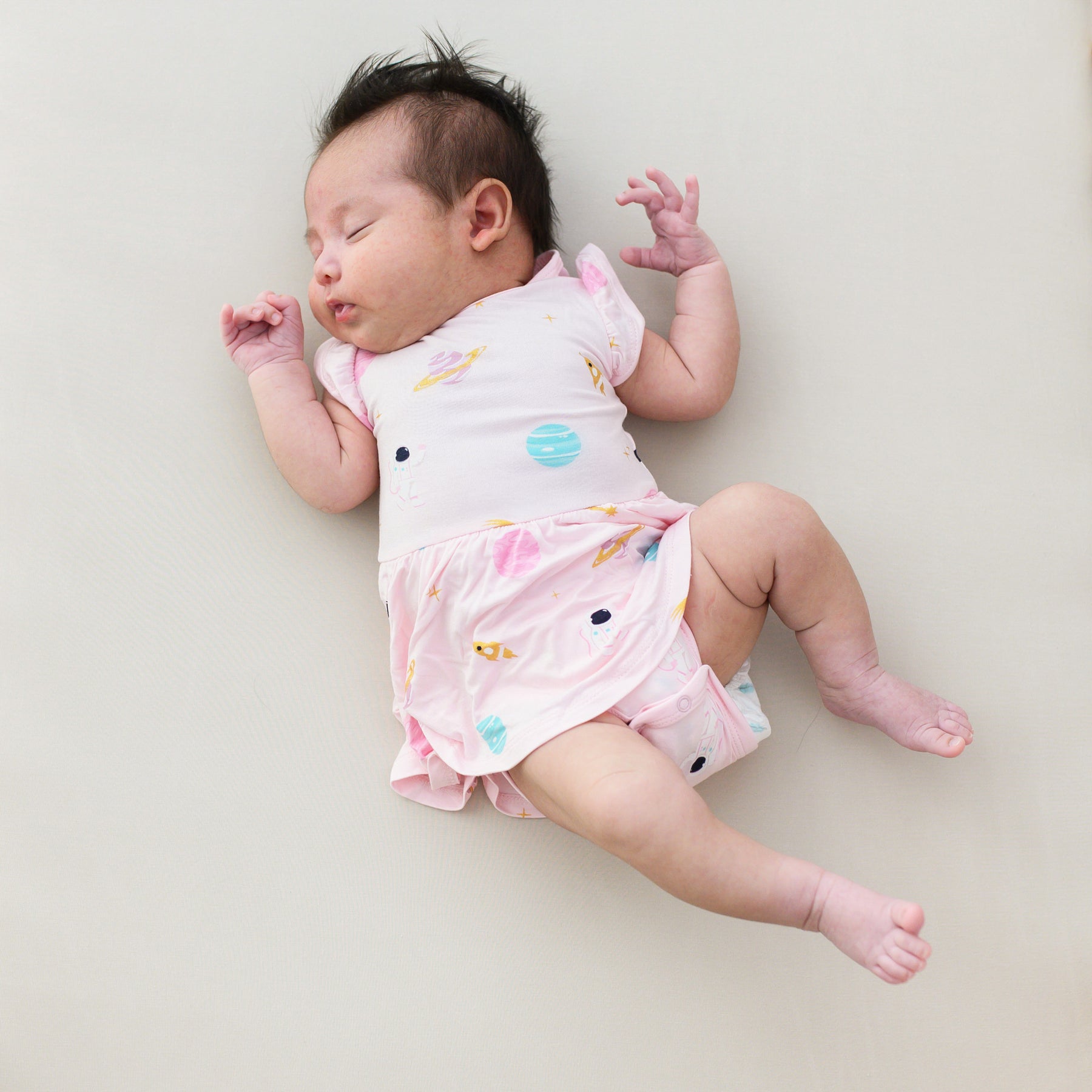 baby sleeping wearing twirl bodysuit dress in sakura space