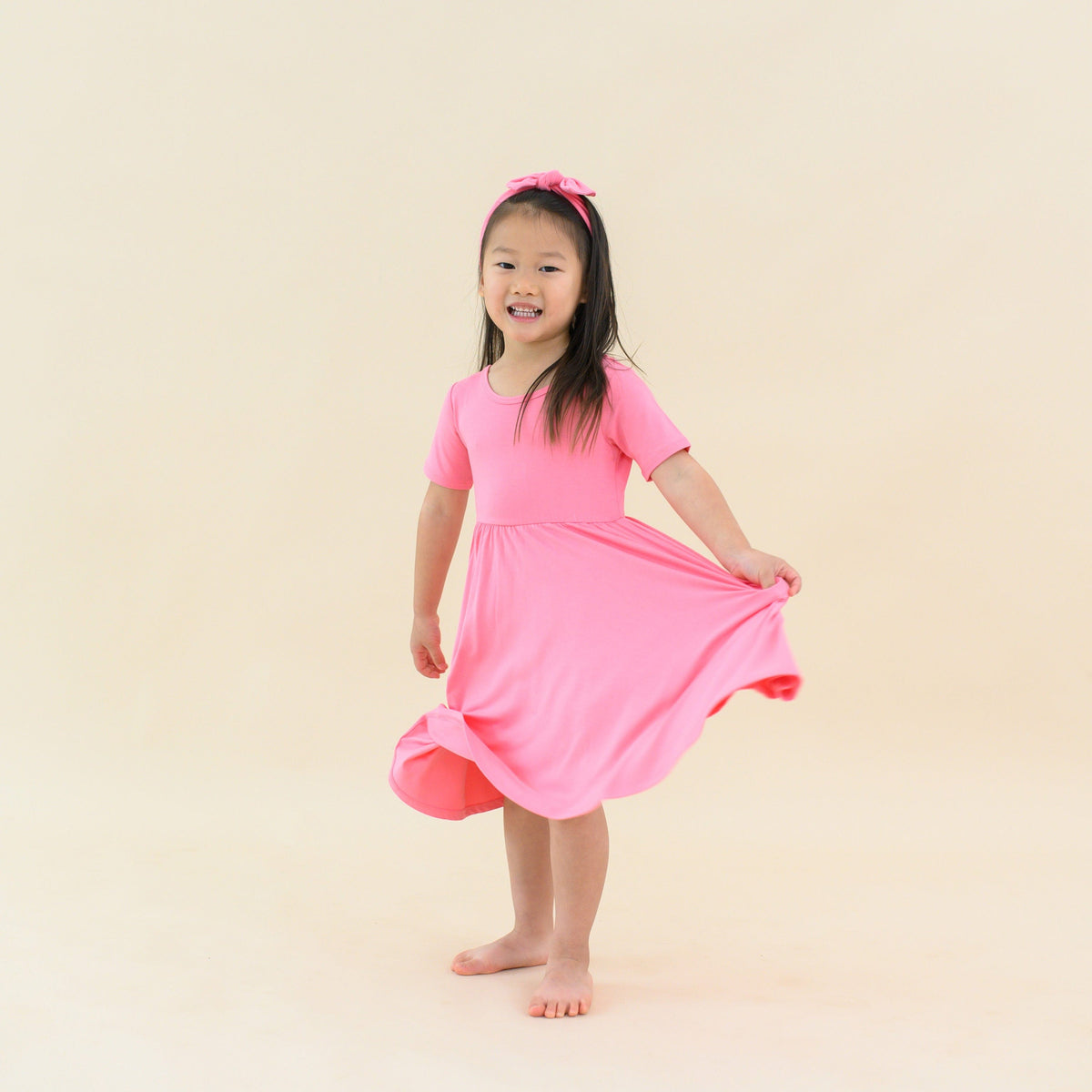 toddler in twirl dress in guava