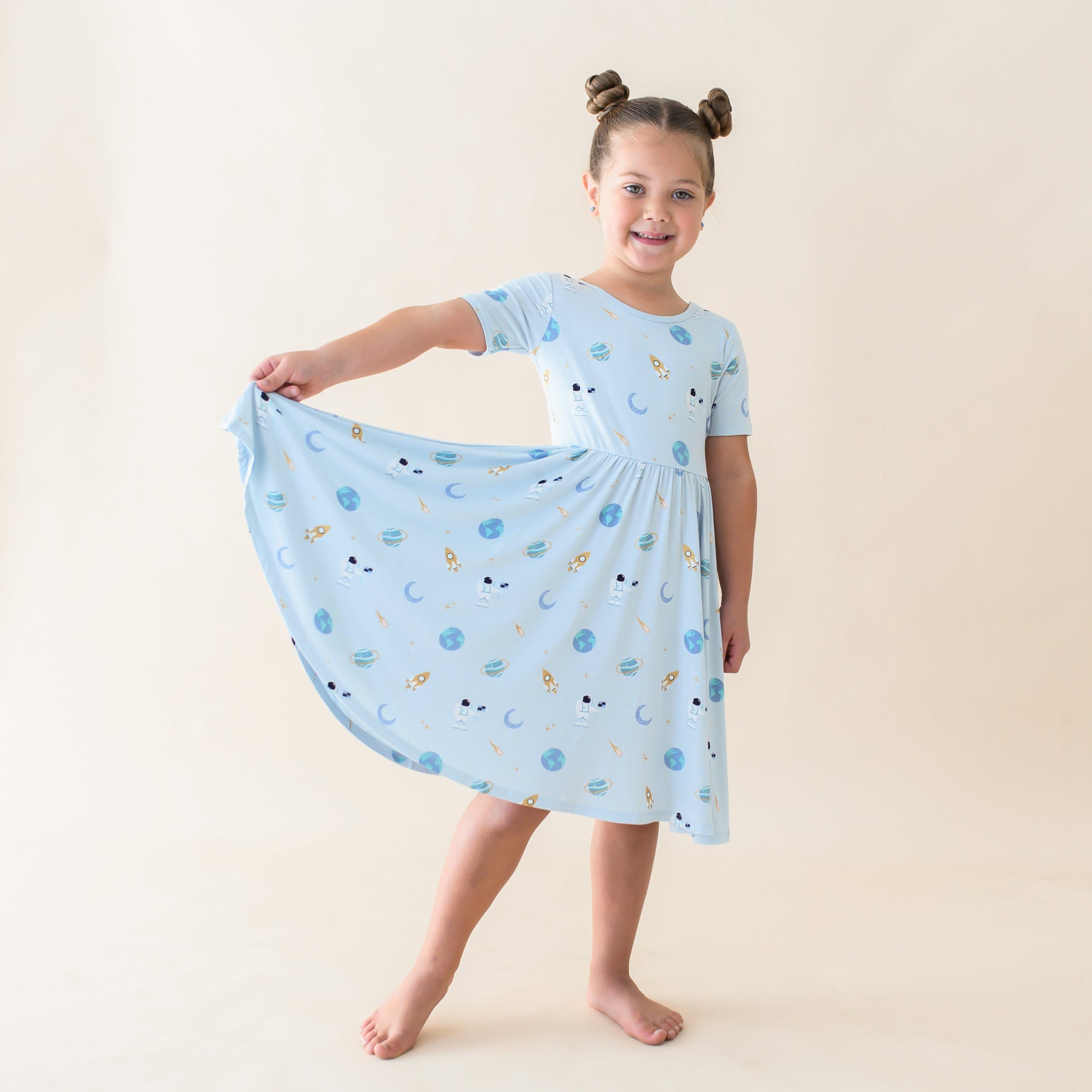 toddler wearing ice space twirl dress holding out side of skirt