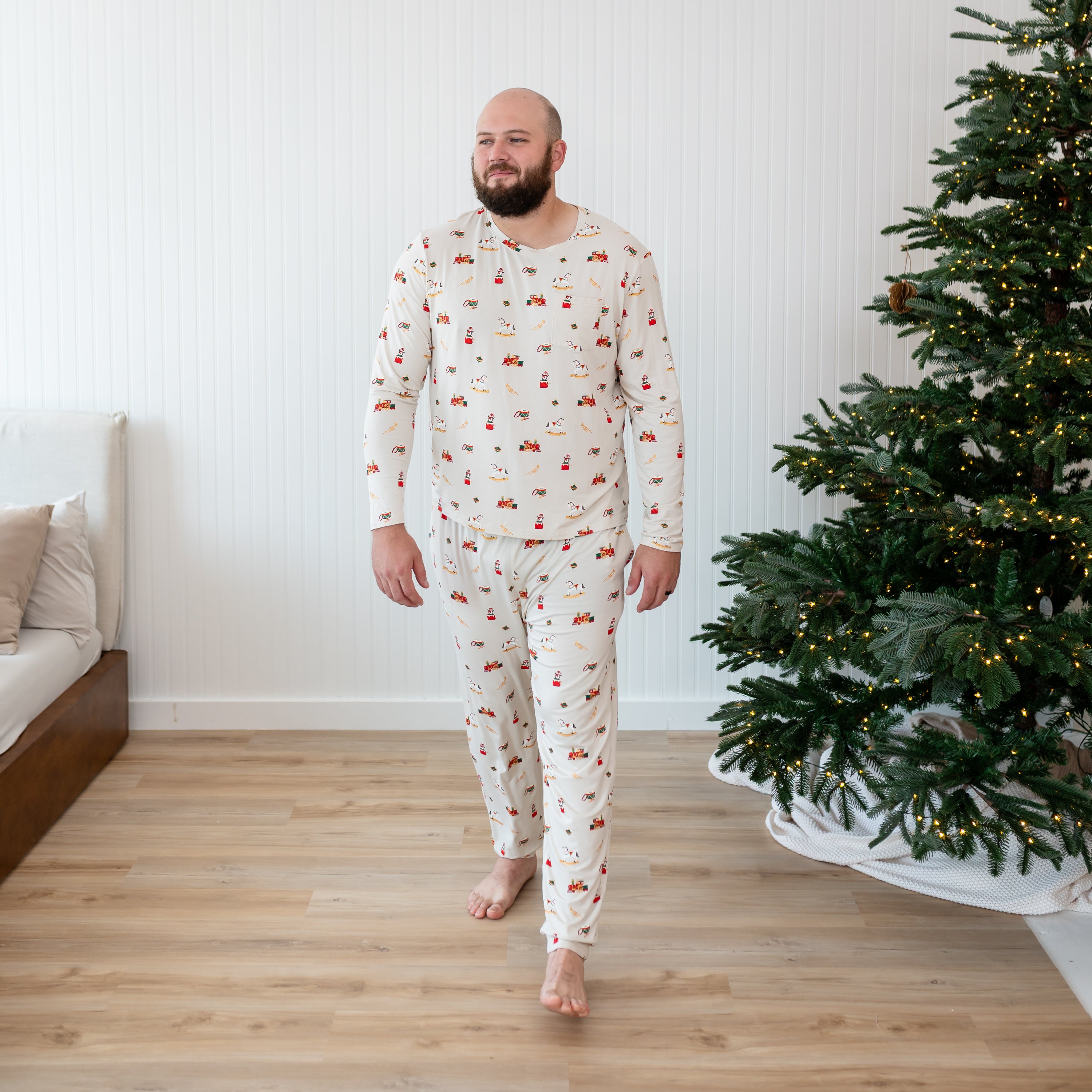 Male model walking in front of a white paneled wall wearing the Men's Jogger Set in Vintage Toys