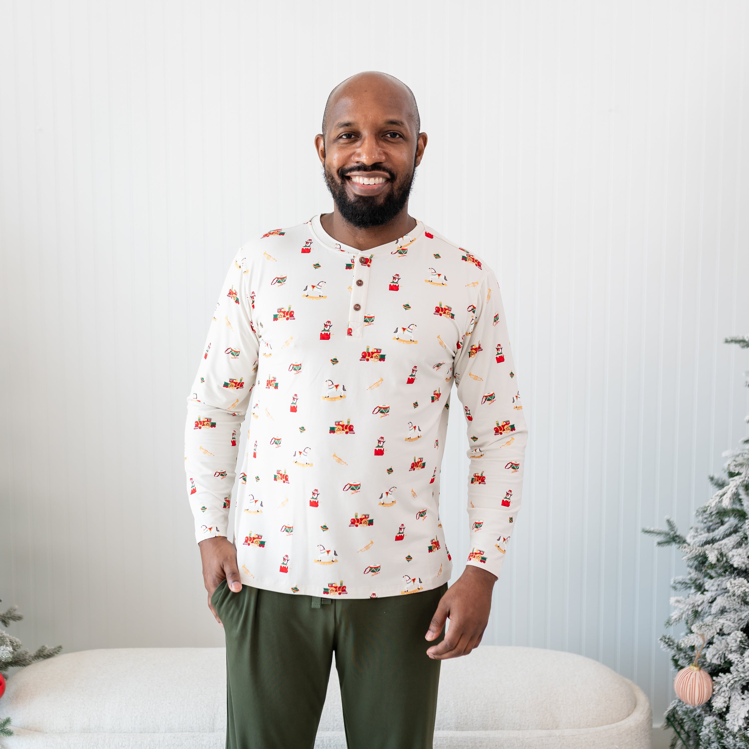 Male model standing wearing the Men's Long Sleeve Henley Top in Vintage Toys with one hand in the pocket of the Fir Lounge pants