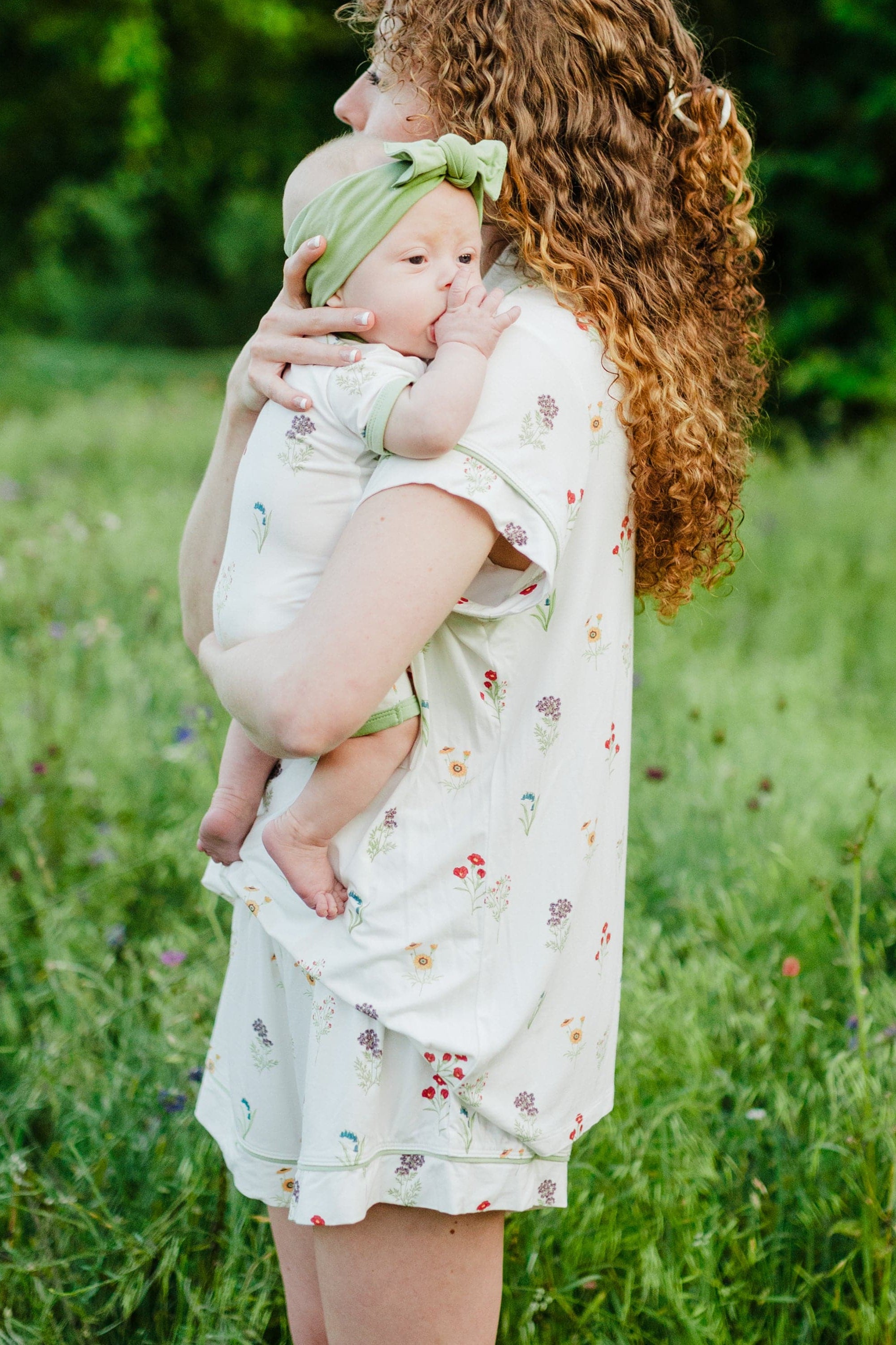 Woman modeling Women’s Short Sleeve Pajama Set in Wildflower while holding baby side view