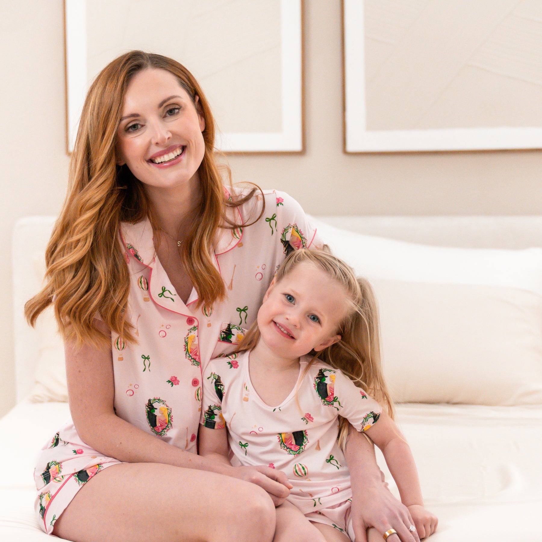 Mother and daughter sitting on a bed matching in short sleeve pajamas in the Wicked print