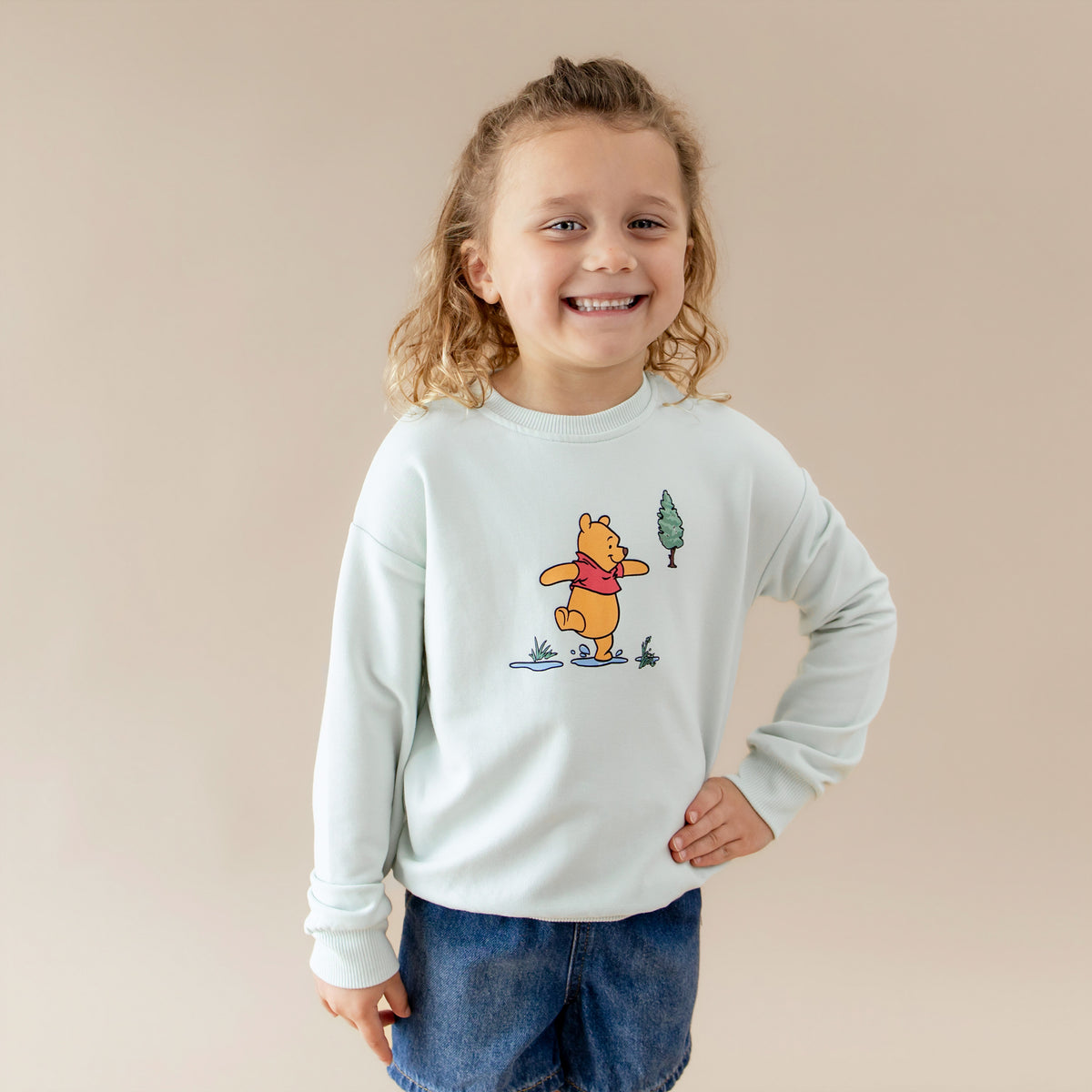 Young child modeling the Sweatshirt in Winnie the Pooh on Dew with one hand on their hip