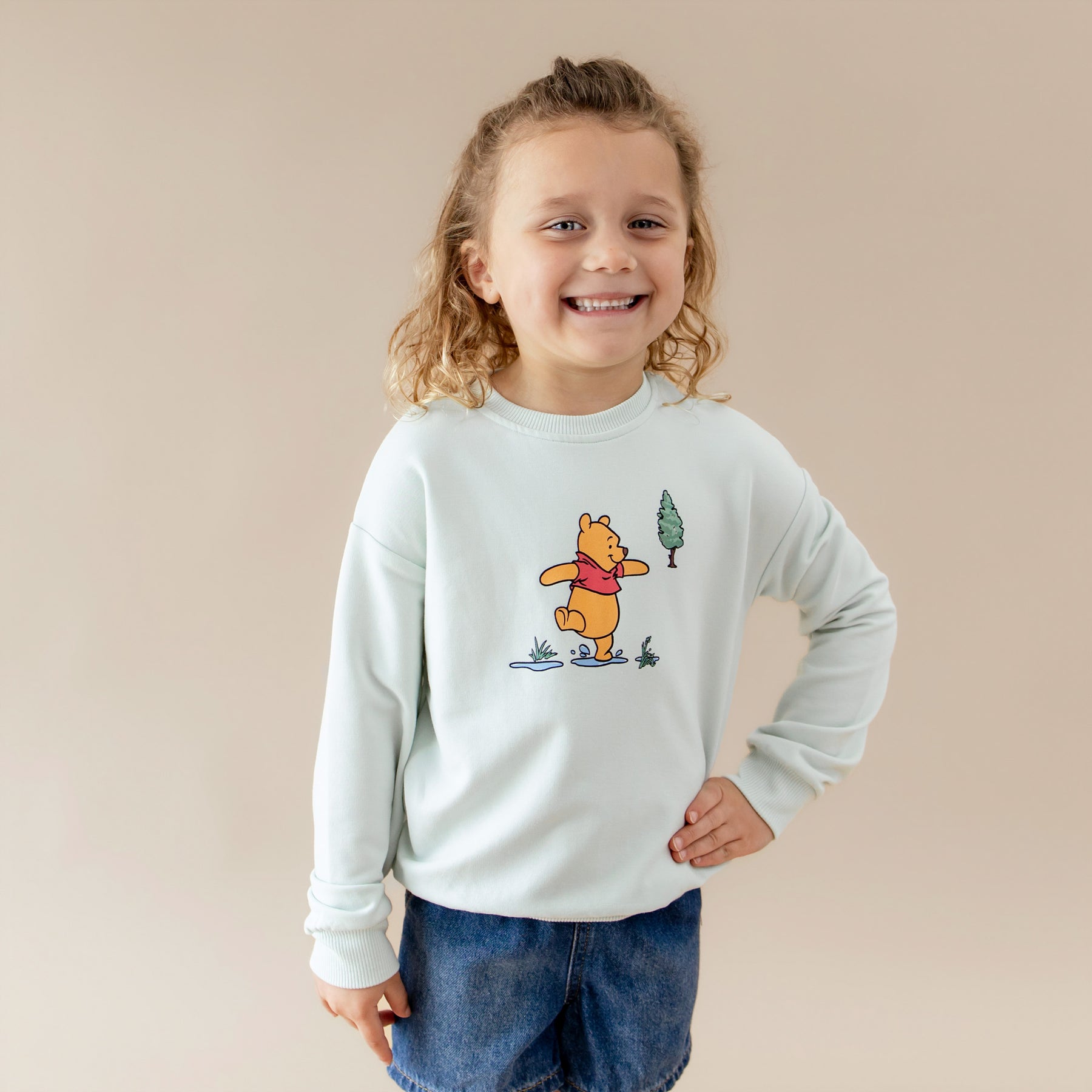 Young child modeling the Sweatshirt in Winnie the Pooh on Dew with one hand on their hip