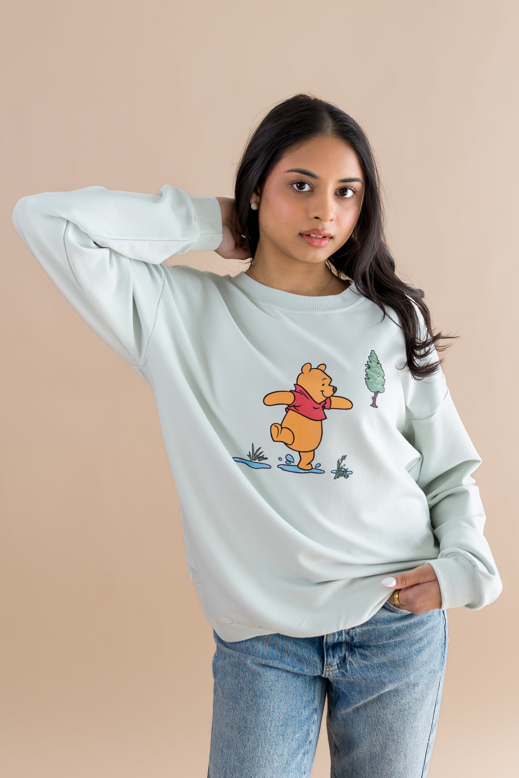 Female model posing wearing the Women's Sweatshirt in Winnie the Pooh on Dew