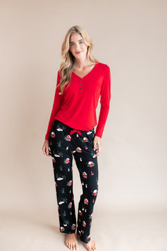 Modal wearing Women's lounge pants in winter wonderland print over red T-shirt on a beige background