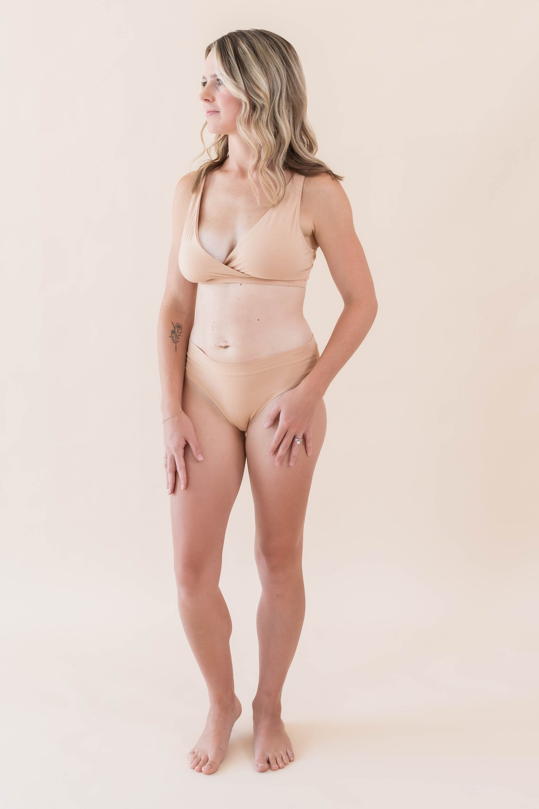 Model posing wearing the Women's Cross Front Bralette in Chai with matching underwear