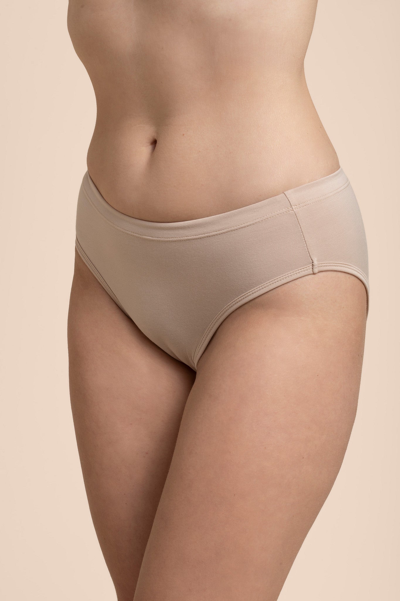 Beige underwear worn by a person on a beige background