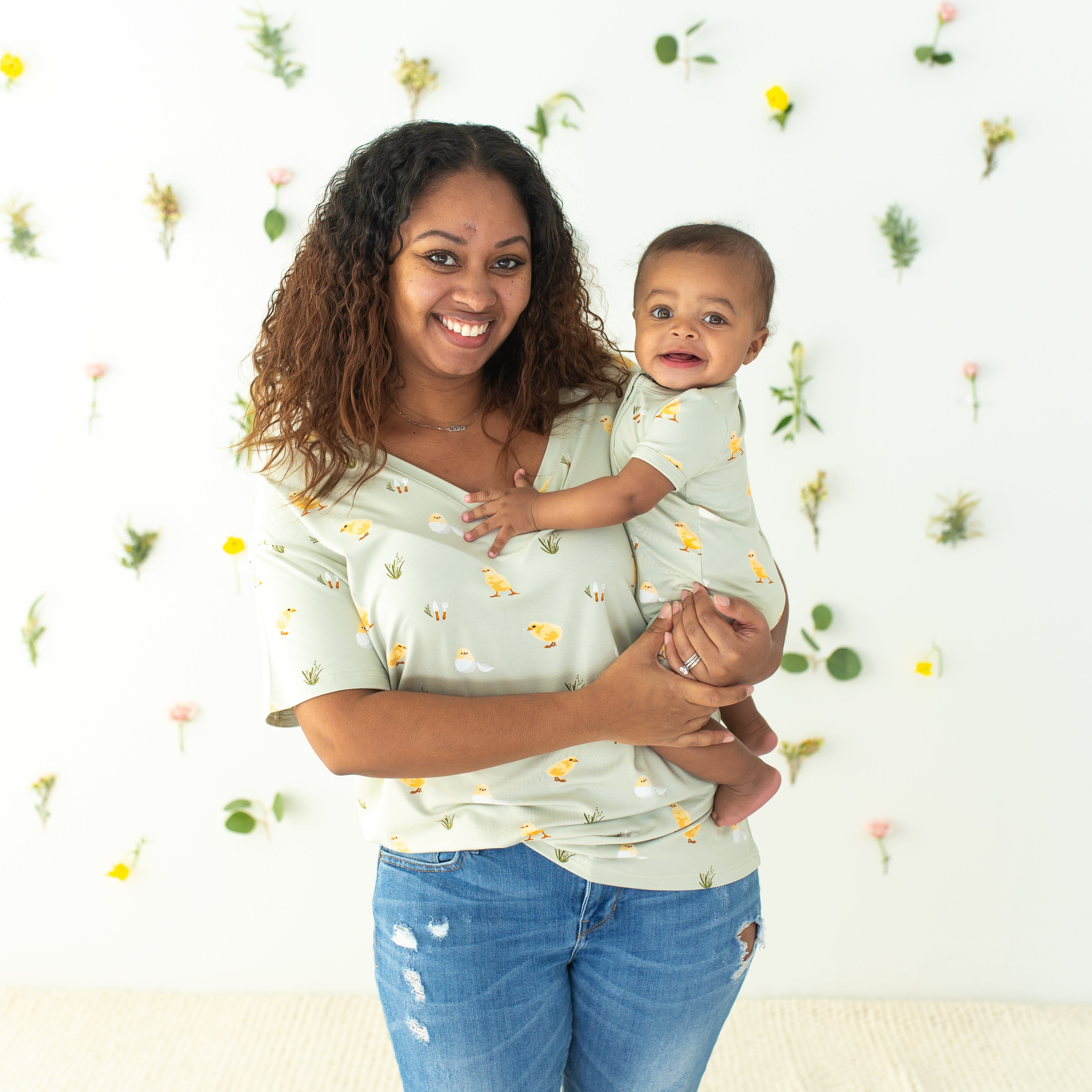 Mom wearing Women’s Relaxed Fit V-Neck in Aloe Chick holding baby