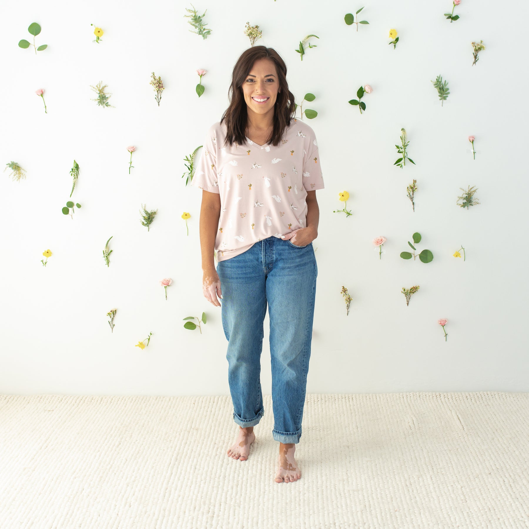 Model wearing Women’s Relaxed Fit V-Neck in Blush Rabbit with floral background