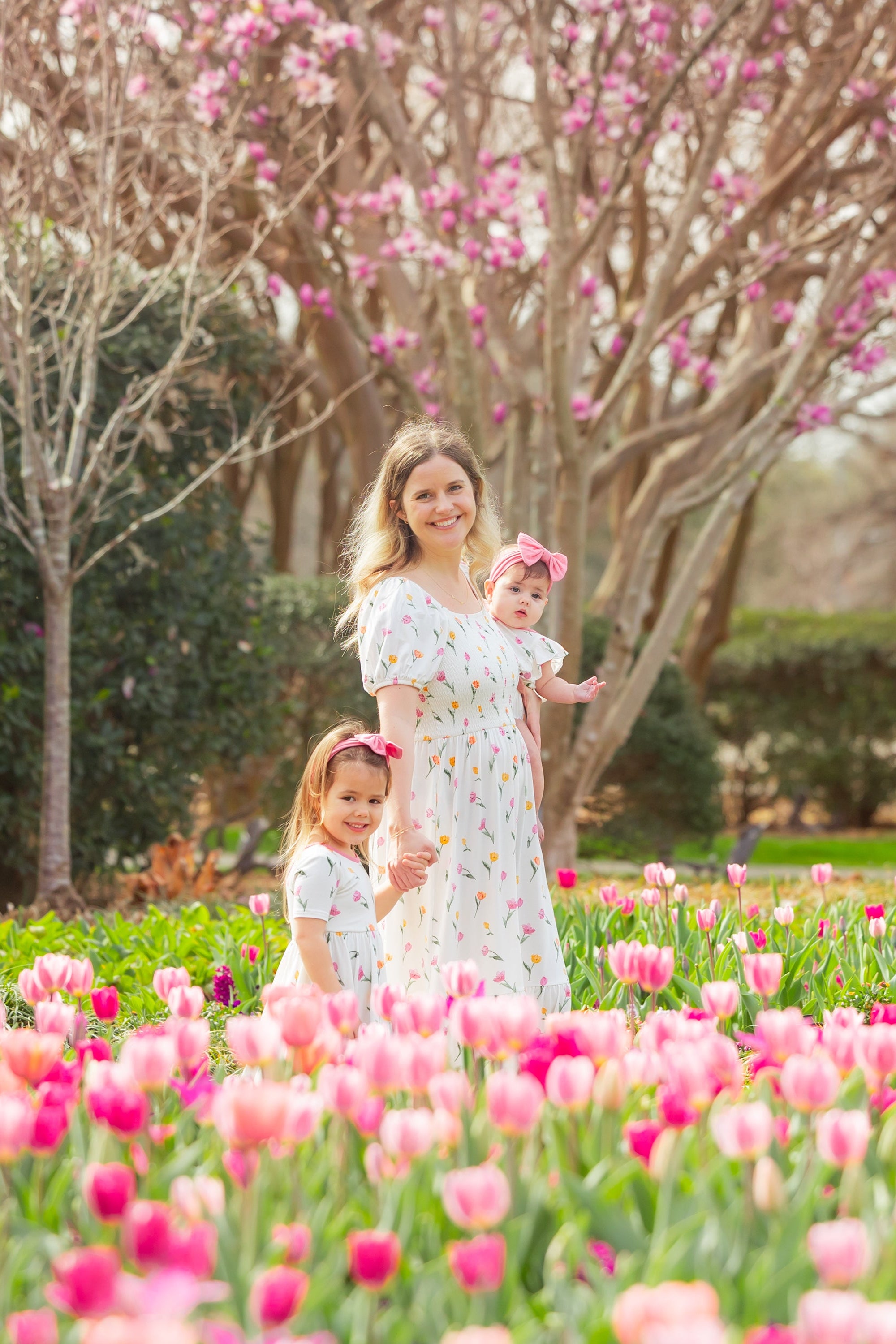 Mother with her two daughter wearing dresses from the tulip collection in a field of tulips