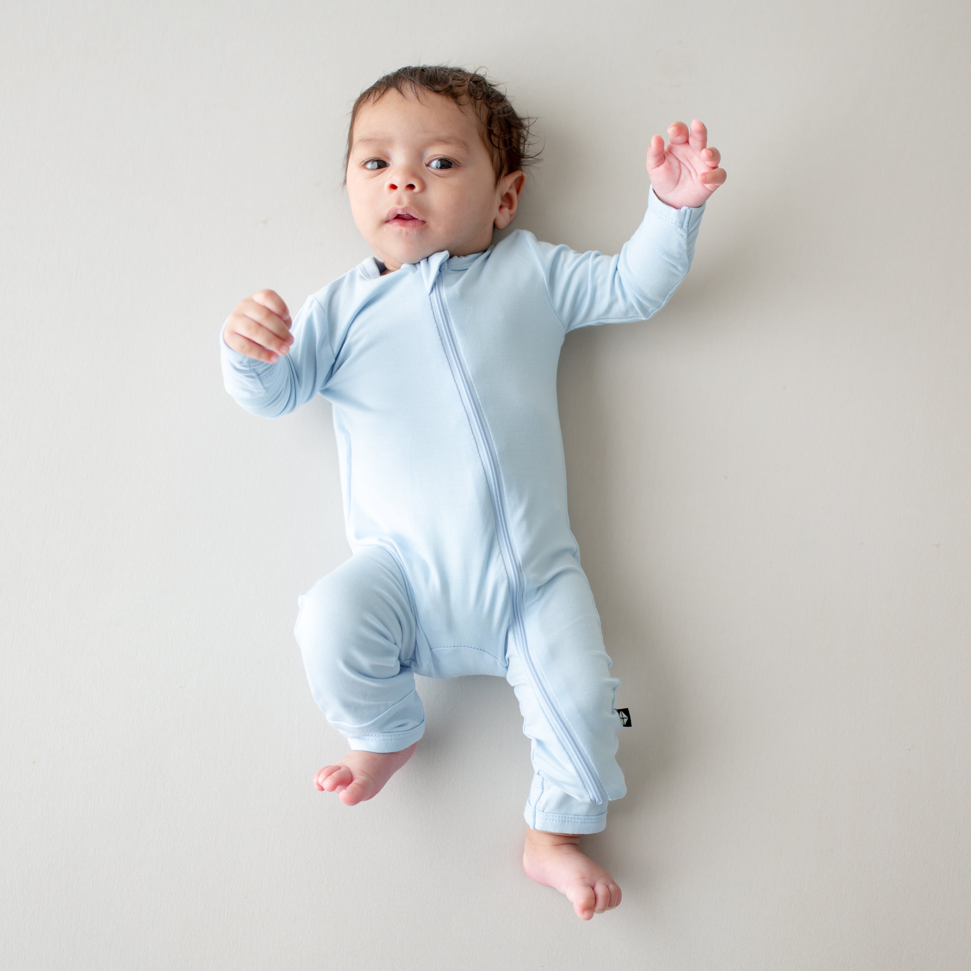 Baby wearing light blue romper with zipper