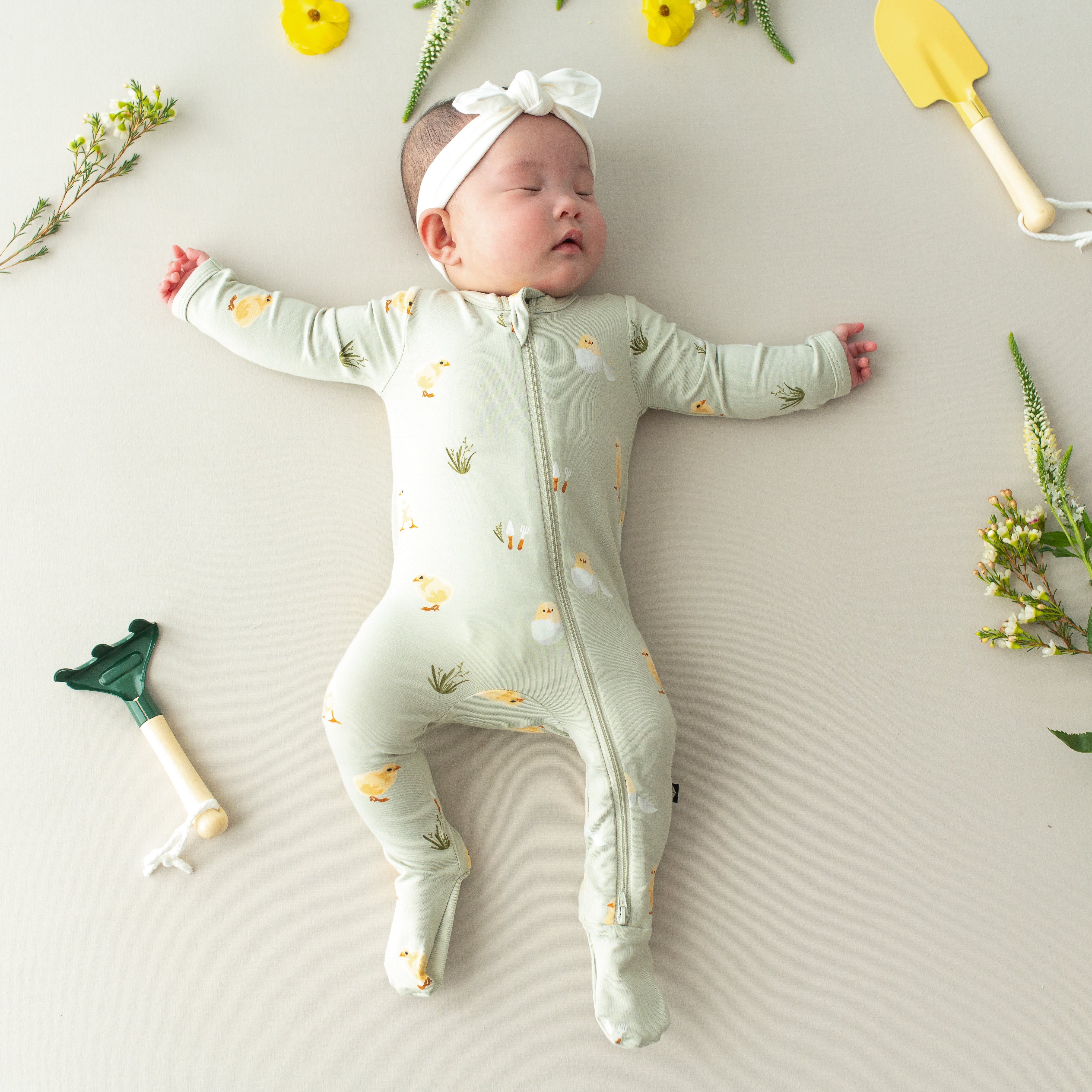 Baby sleeping wearing Zippered Footie in Aloe Chick