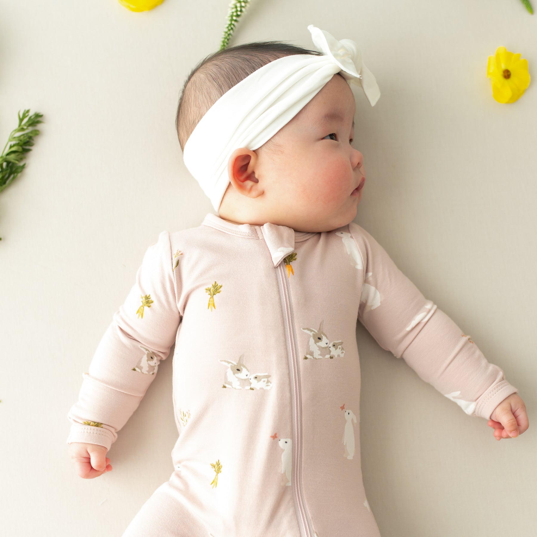 close up of baby wearing Zippered Footie in Blush Rabbit