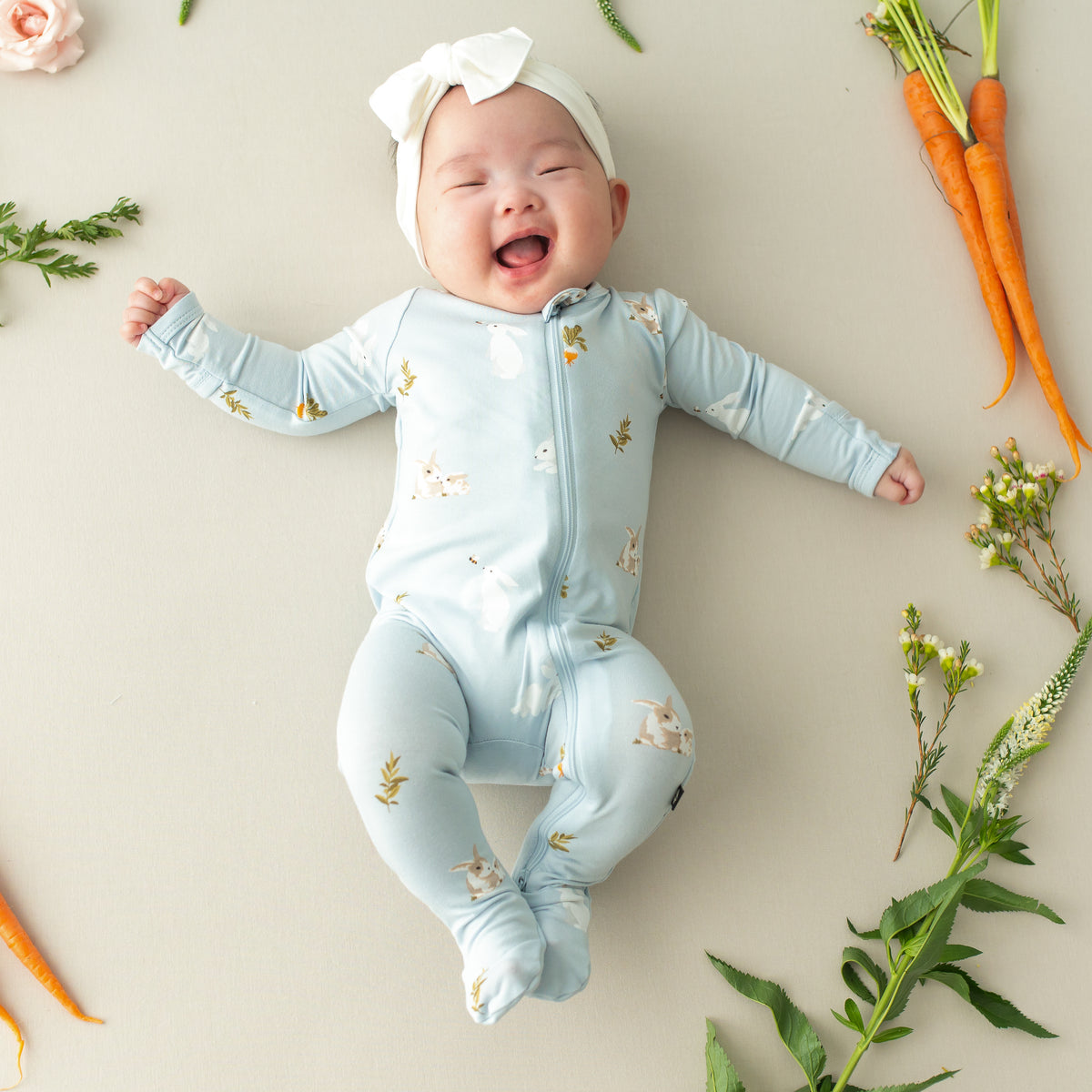 Baby smiling wearing Zippered Footie in Ice Rabbit