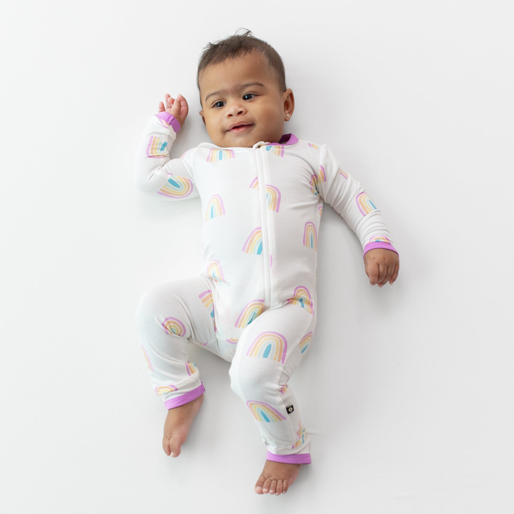 Baby smiling wearing Zippered Romper in Poi Rainbow