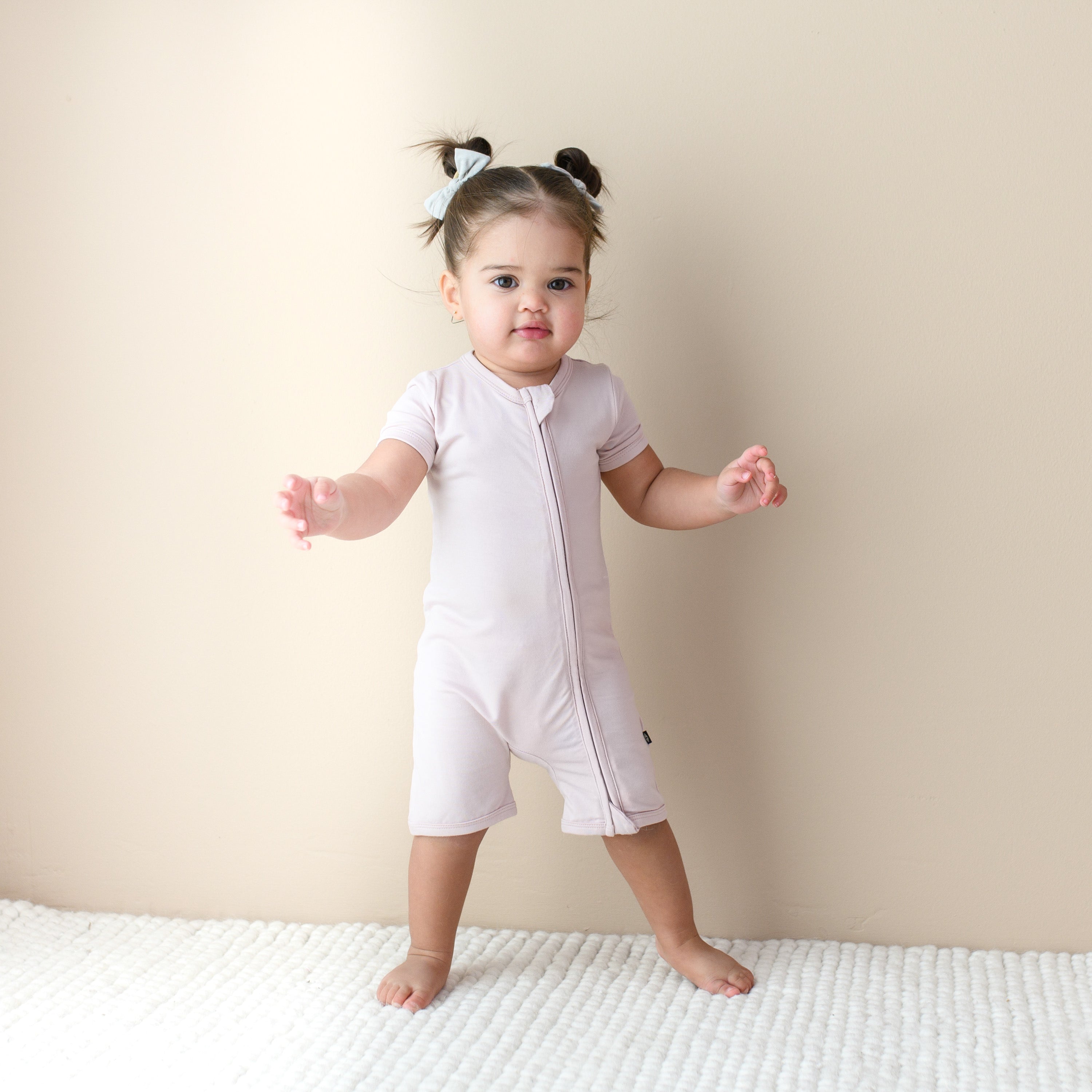 Toddler modeling Zipper Shortall Romper in Blush