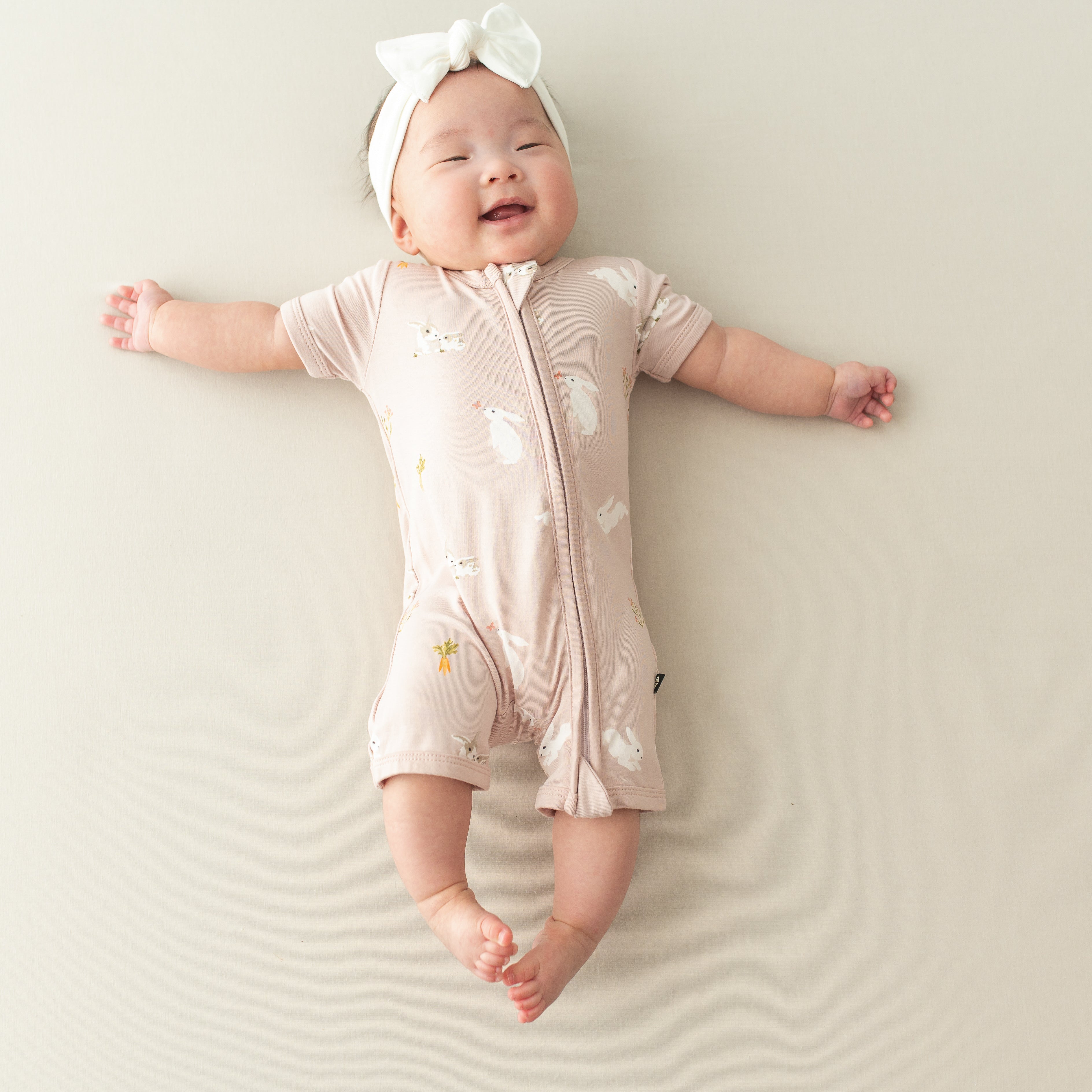 baby wearing Zipper Shortall Romper in Blush Rabbit