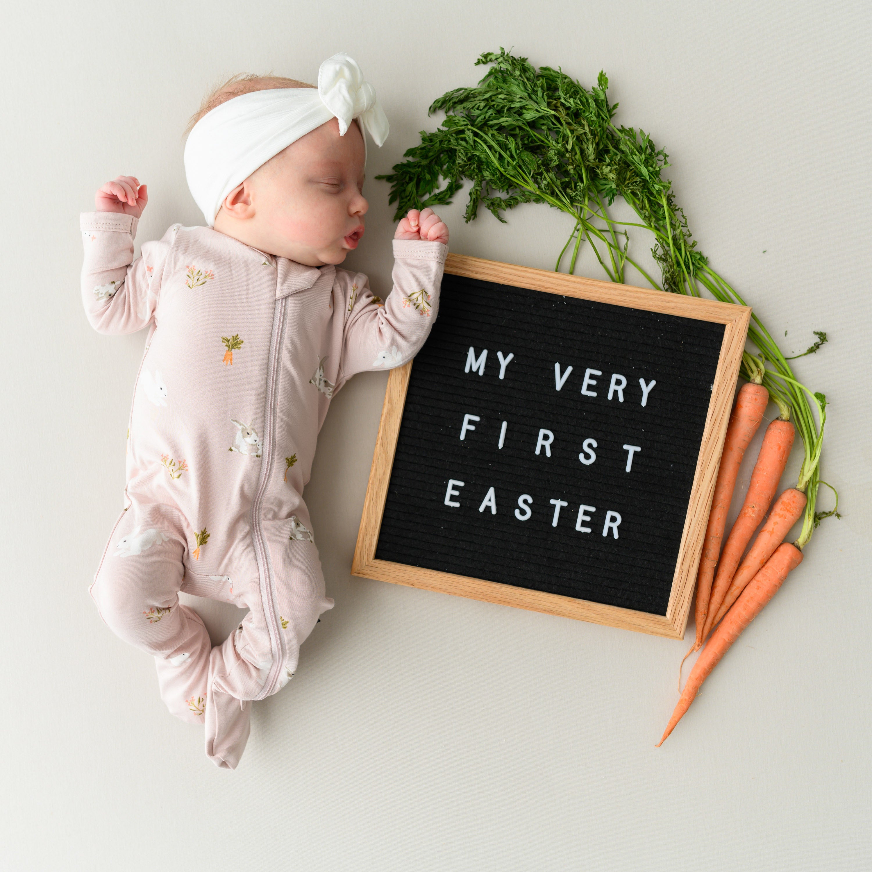 baby next to a first easter sign wearing Zippered Footie in Blush Rabbit