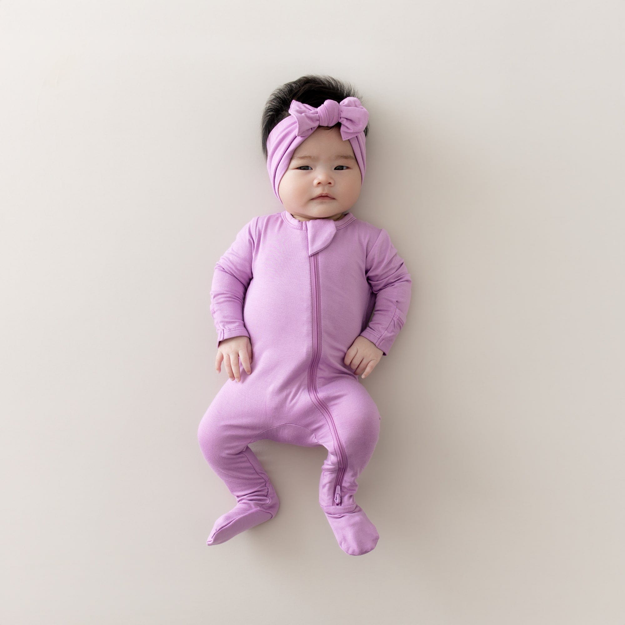 baby modeling kyte baby zippered footie and bow in poi 