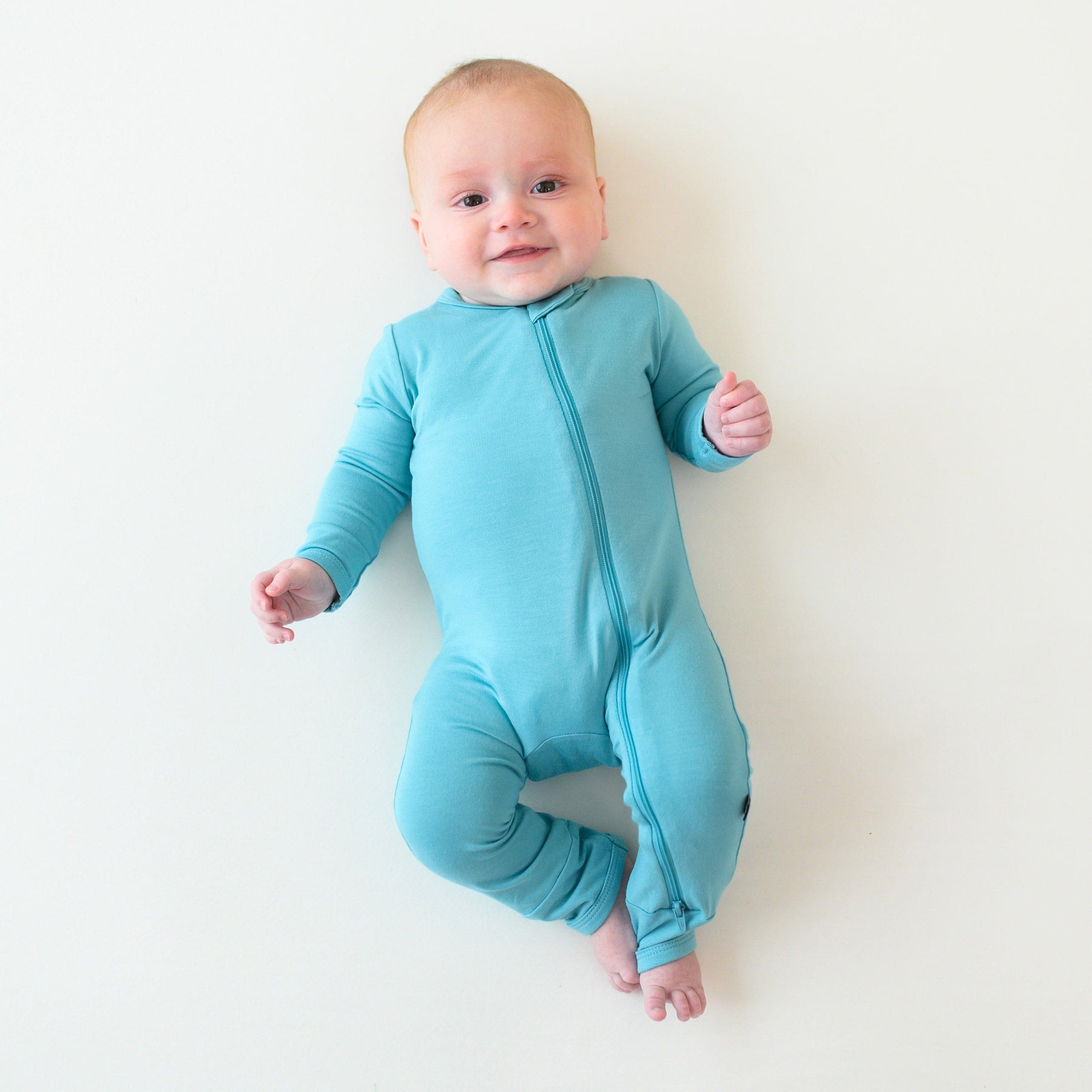 baby wearing kyte baby zippered romper in makai