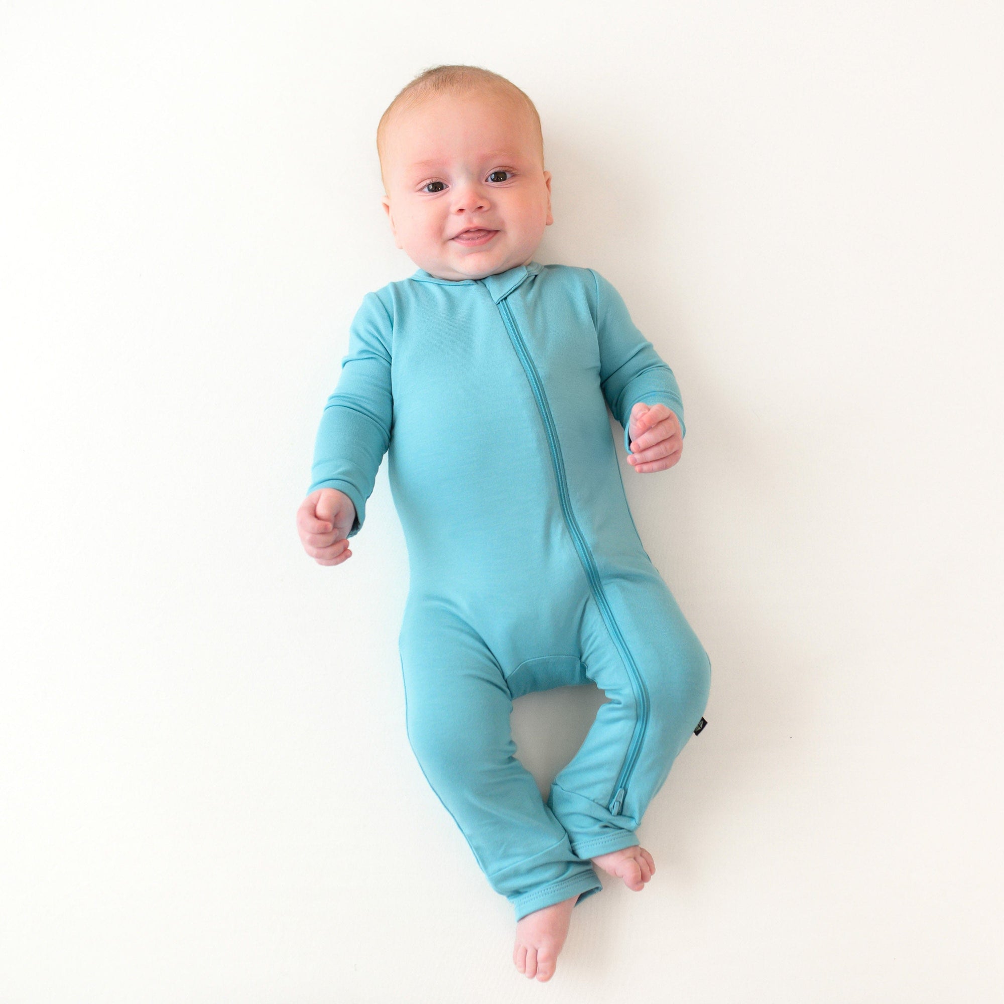 baby wearing zippered romper in makai