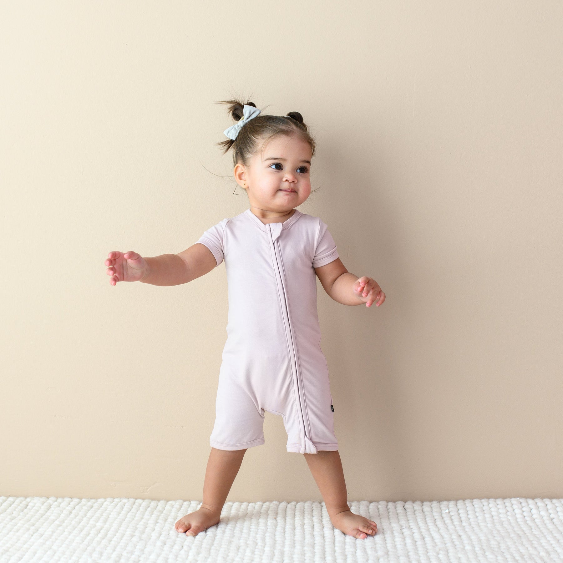 Toddler modeling Zipper Shortall Romper in Blush