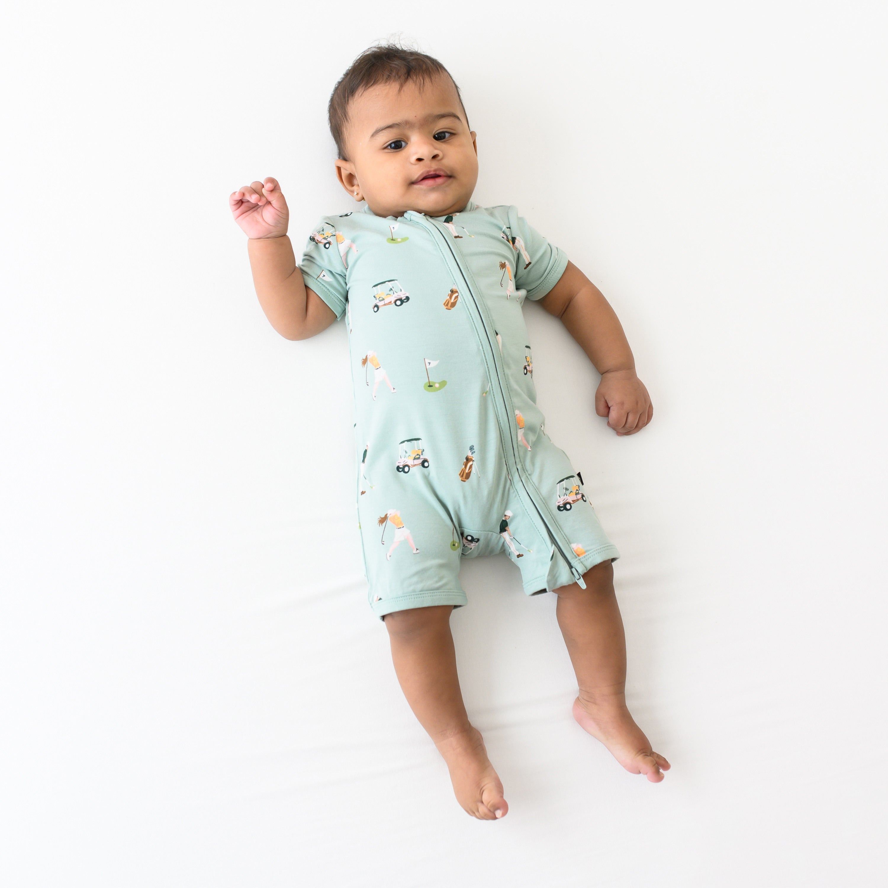 Baby modeling Zippered Shortall Romper in Golf