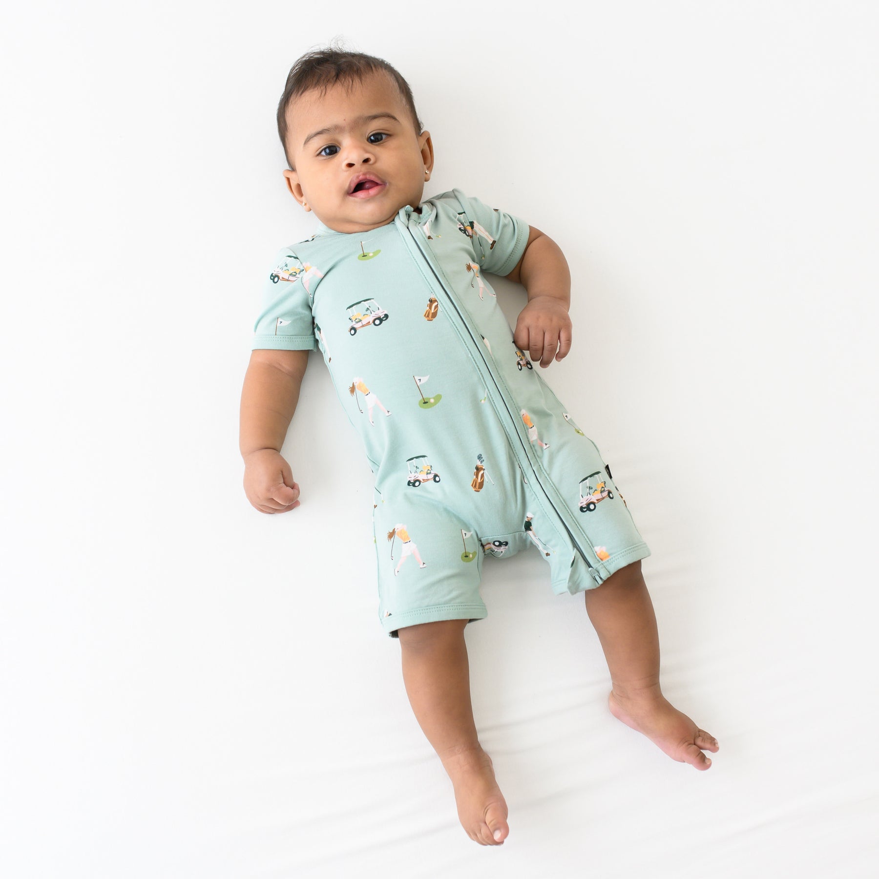 Baby modeling Zippered Shortall Romper in Golf