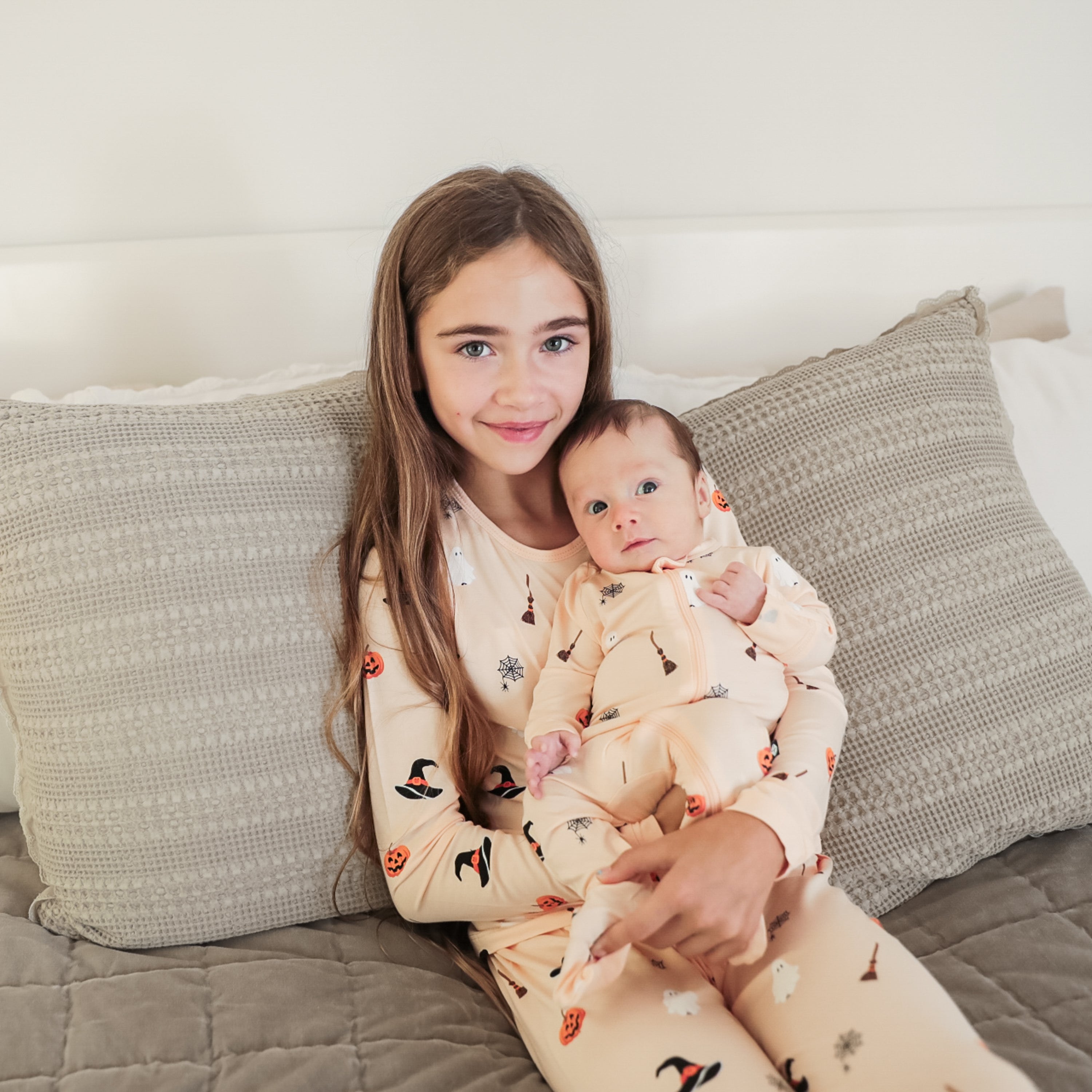 Siblings in matching pajamas in Bewitched Halloween print