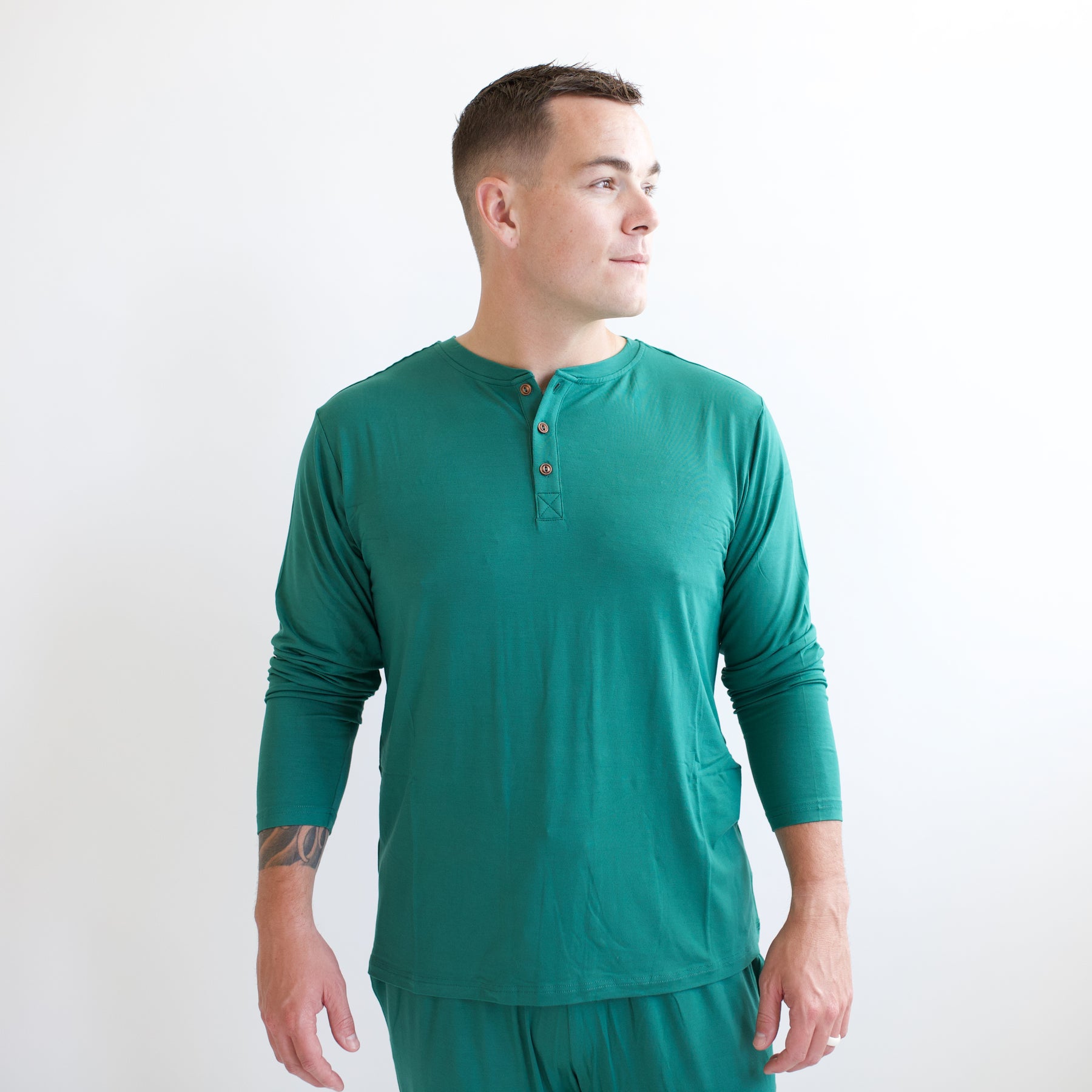 Men's Long Sleeve Henley Top in Emerald shown on a male model standing in front of a white background