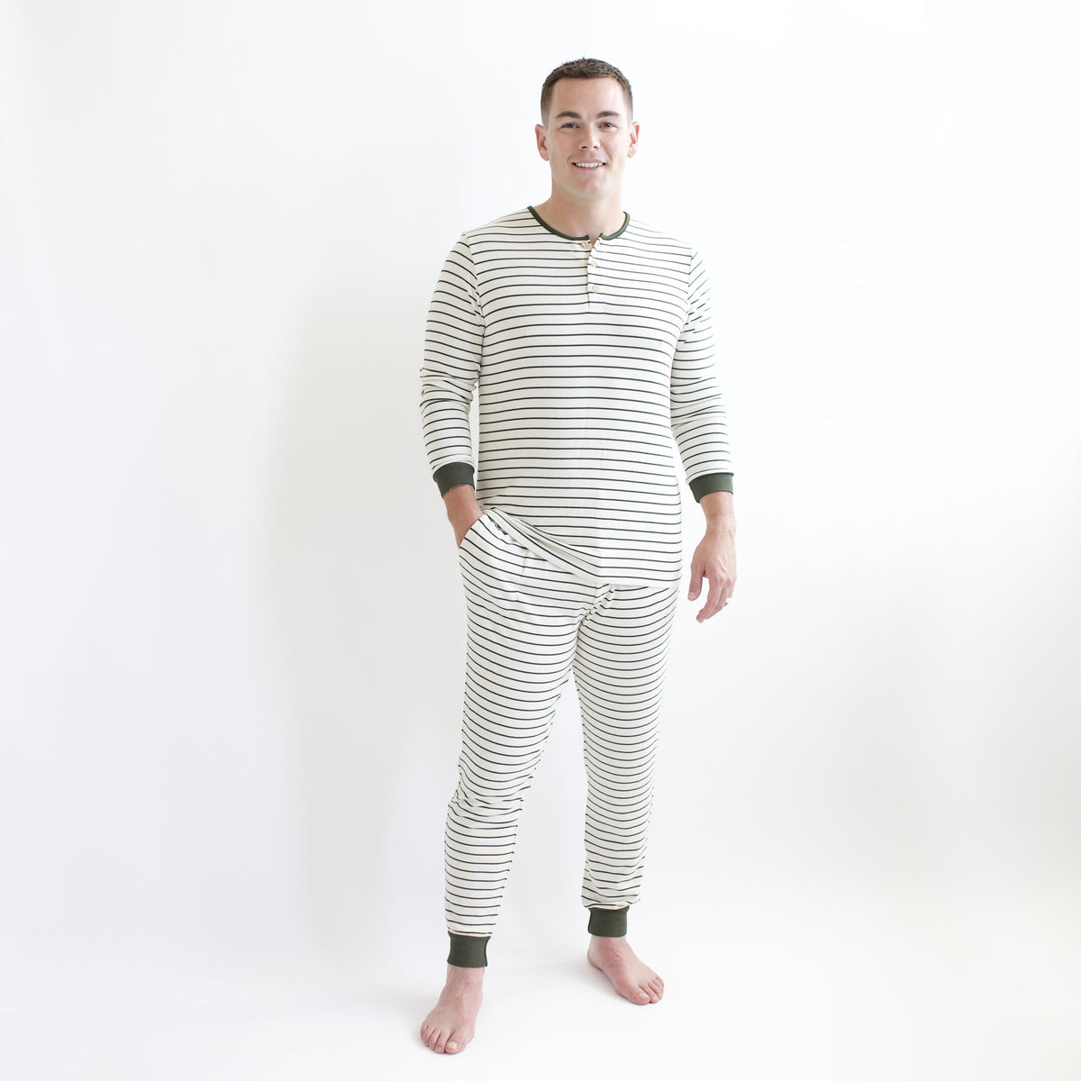 Male model wearing the Men's Ribbed Henley Set in Fir Stripe standing in front of a white backdrop
